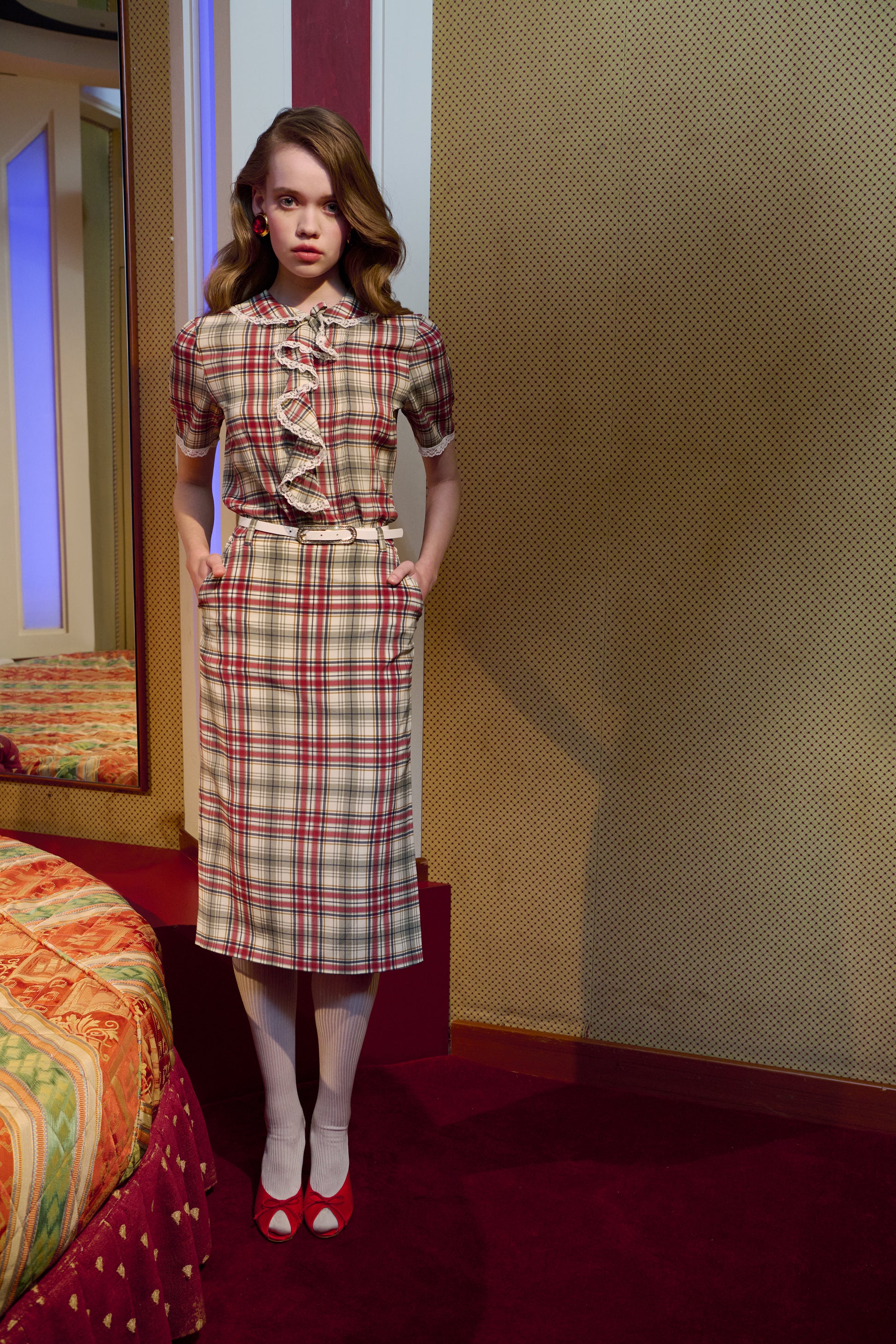 Red and green tartan-print  silk crêpe de chine blouse with small collar, jabot and short sleeves all trimmed in white lace. The blouse is fastened with a back button closure.

Look 32 – Fall Winter 2026 Lookbook.