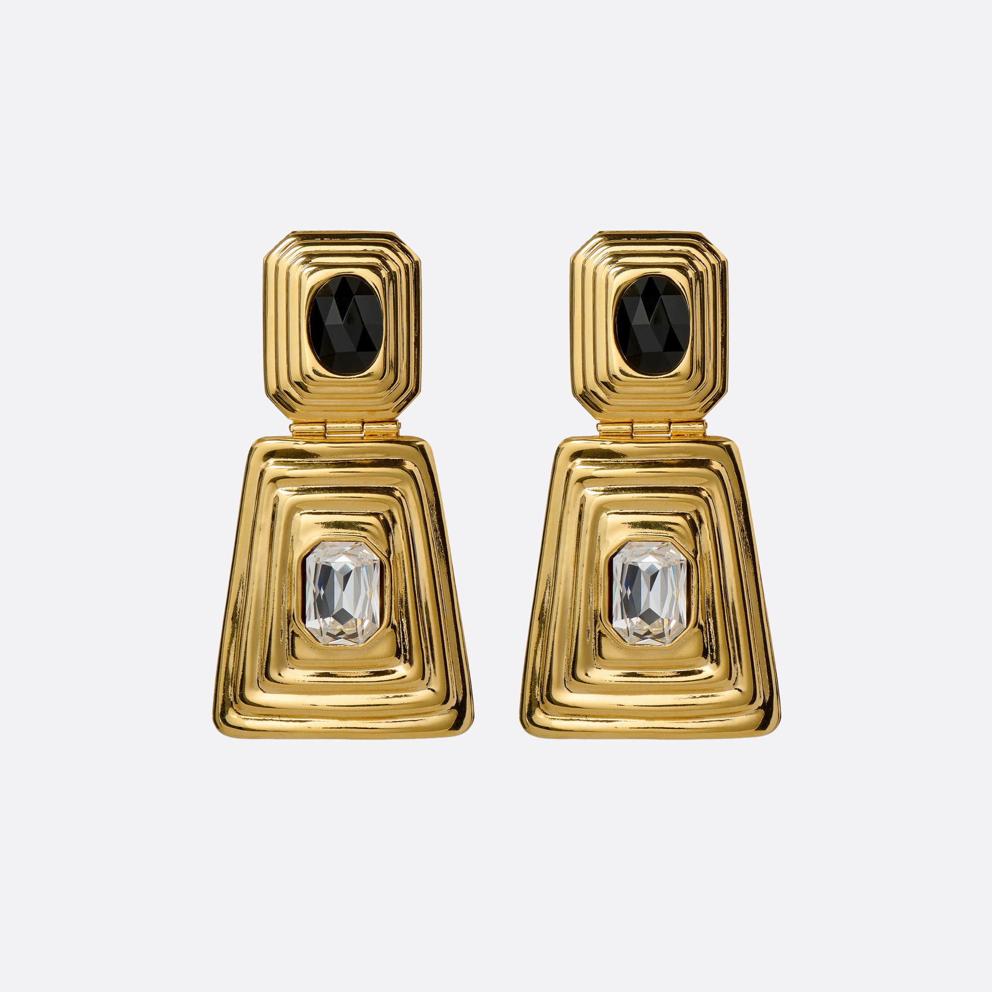 Gold-tone metal clip-on earrings with a black crystal detail and clear crystal pendant drop.

Featured in the Fall Winter 2026 Lookbook.