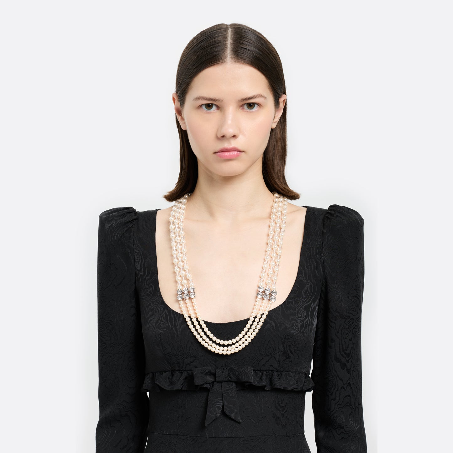 Multi-strand pearl necklace detailed with crystal embellishments and clear bead accents. Finished with a clasp fastening.

Featured in the Fall Winter 2026 Lookbook.