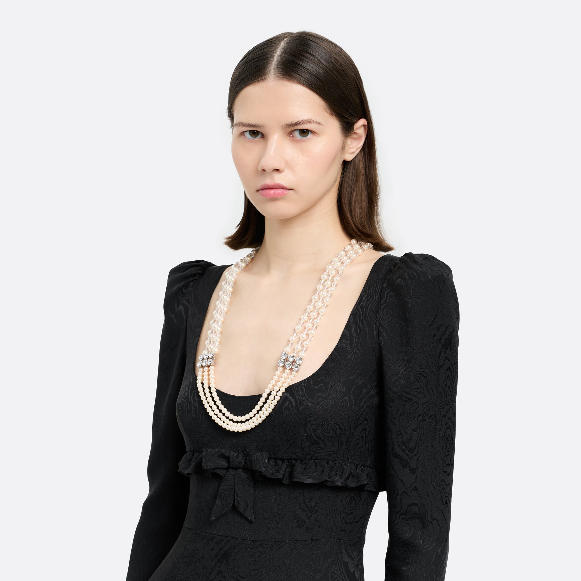 Multi-strand pearl necklace detailed with crystal embellishments and clear bead accents. Finished with a clasp fastening.

Featured in the Fall Winter 2026 Lookbook.