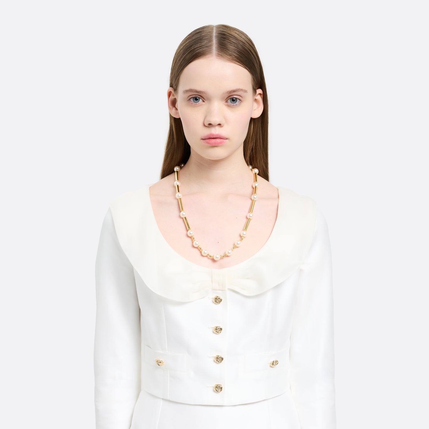 Pearl necklace punctuated by gold-tone metal bar accents. Finished with a crystal detail and clasp fastening.

Featured in the Fall Winter 2026 Lookbook.