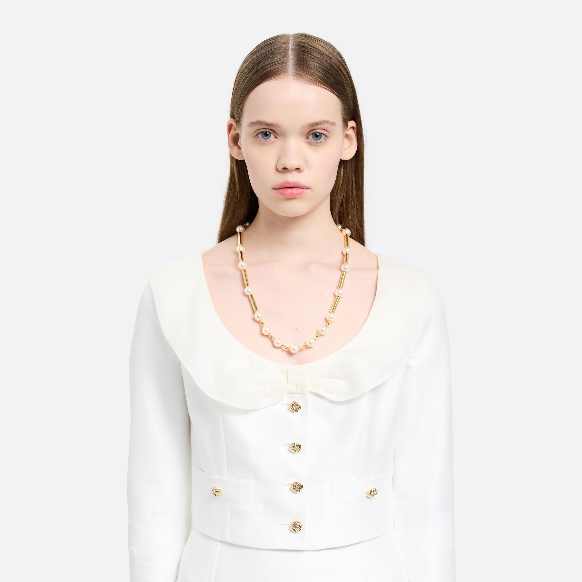 Pearl necklace punctuated by gold-tone metal bar accents. Finished with a crystal detail and clasp fastening.

Featured in the Fall Winter 2026 Lookbook.