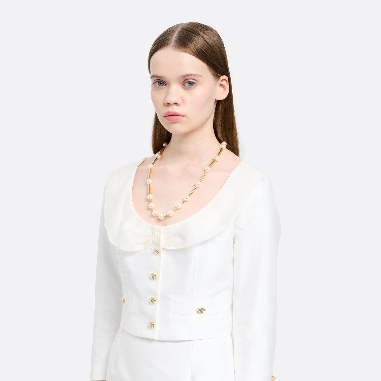 Pearl necklace punctuated by gold-tone metal bar accents. Finished with a crystal detail and clasp fastening.

Featured in the Fall Winter 2026 Lookbook.
