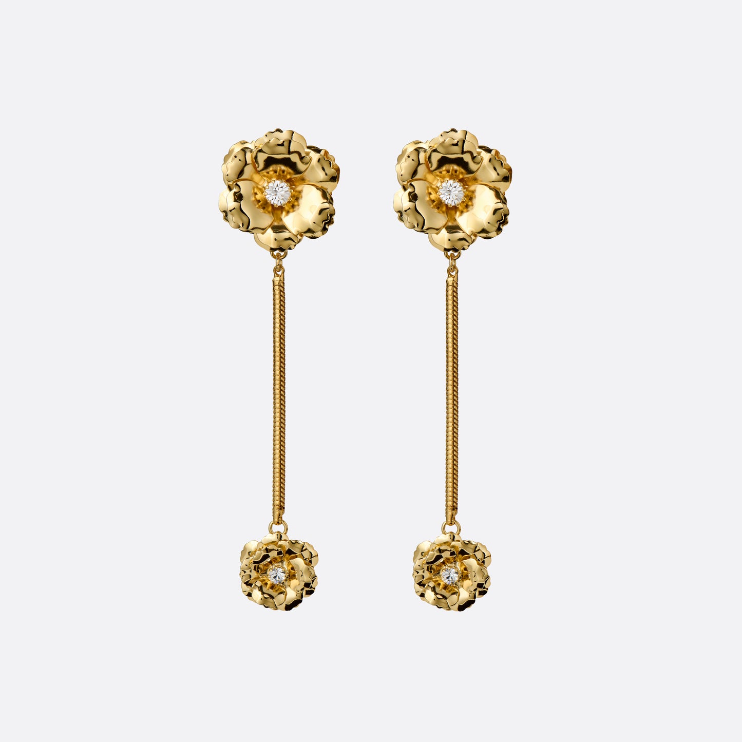 Gold-tone metal clip-on earrings with floral elements, crystal details and a chain drop.
