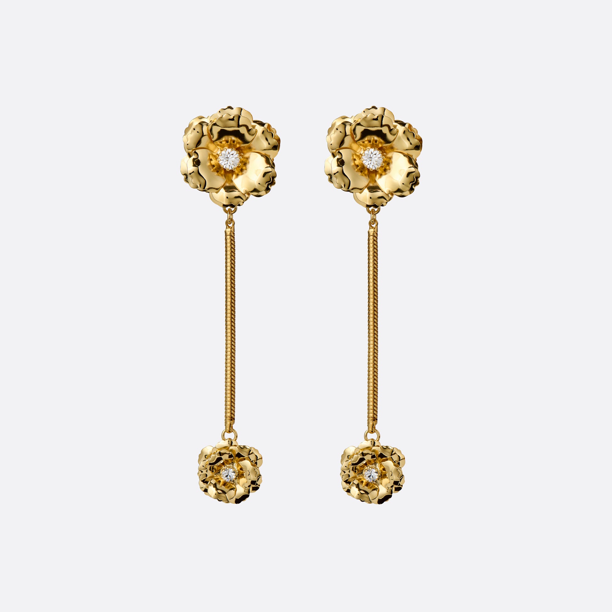 Gold-tone metal clip-on earrings with floral elements, crystal details and a chain drop.