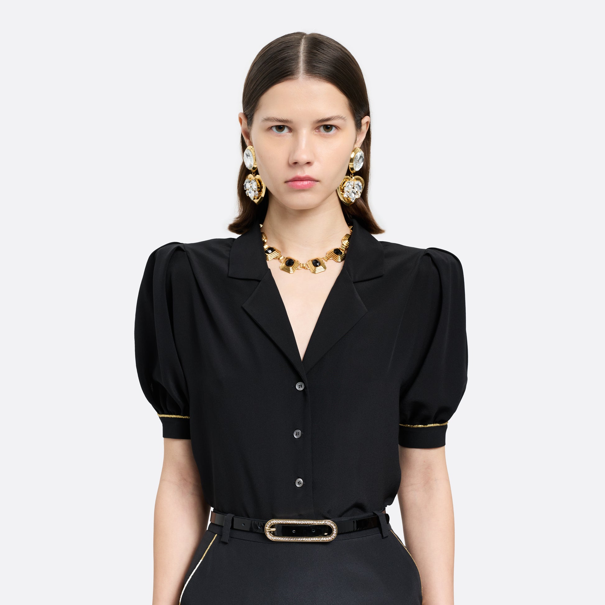 Gold-tone metal clip-on earrings with crystal details and a heart-shaped pendant.

Featured in the Fall Winter 2026 Lookbook.