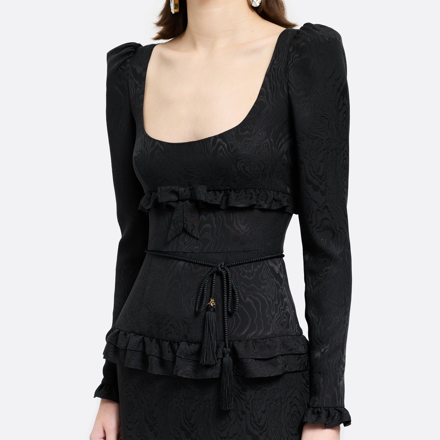 Black braided torchon belt with tassels and gold-tone "AR" logo charm.