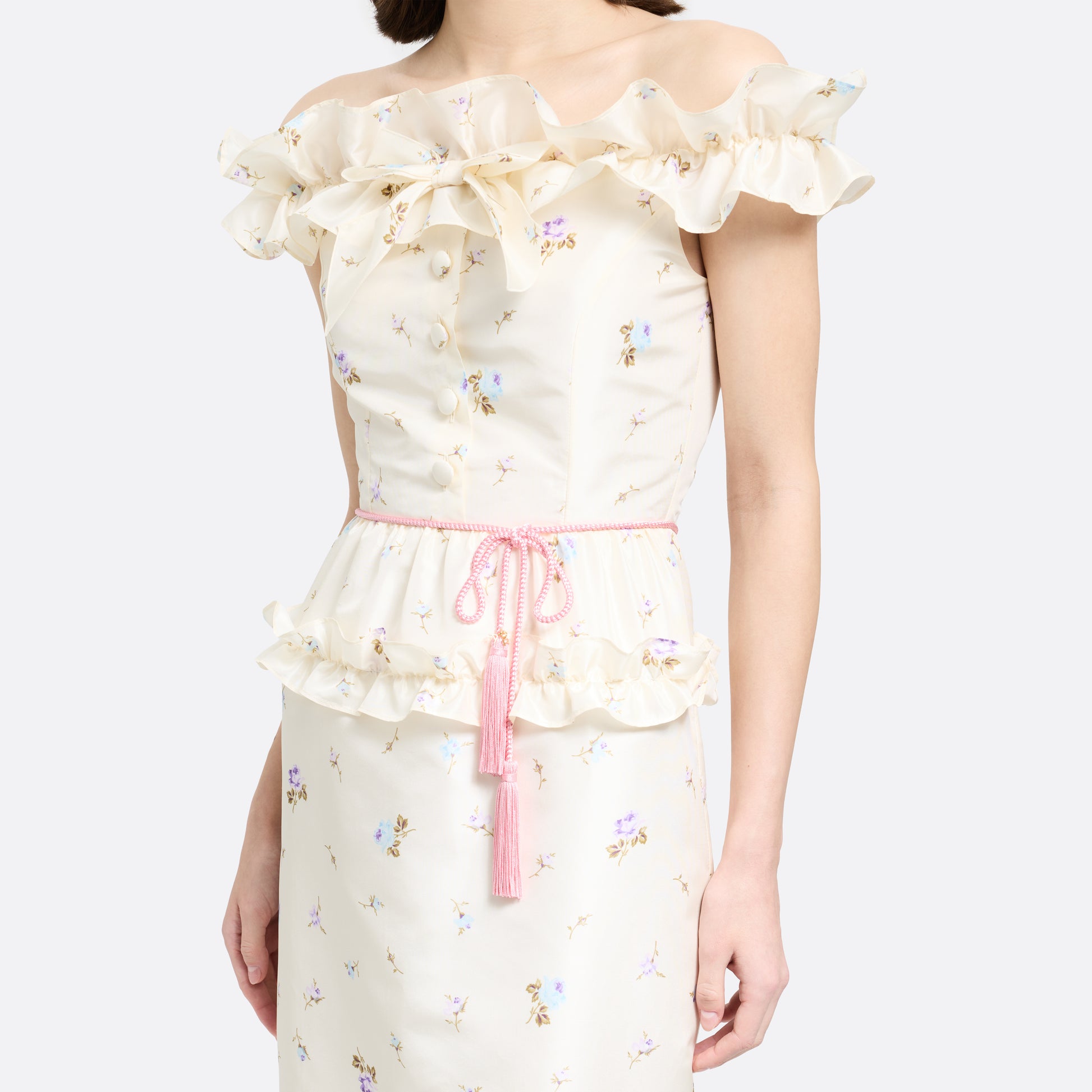 Pink braided torchon belt with tassels and gold-tone "AR" logo charm.