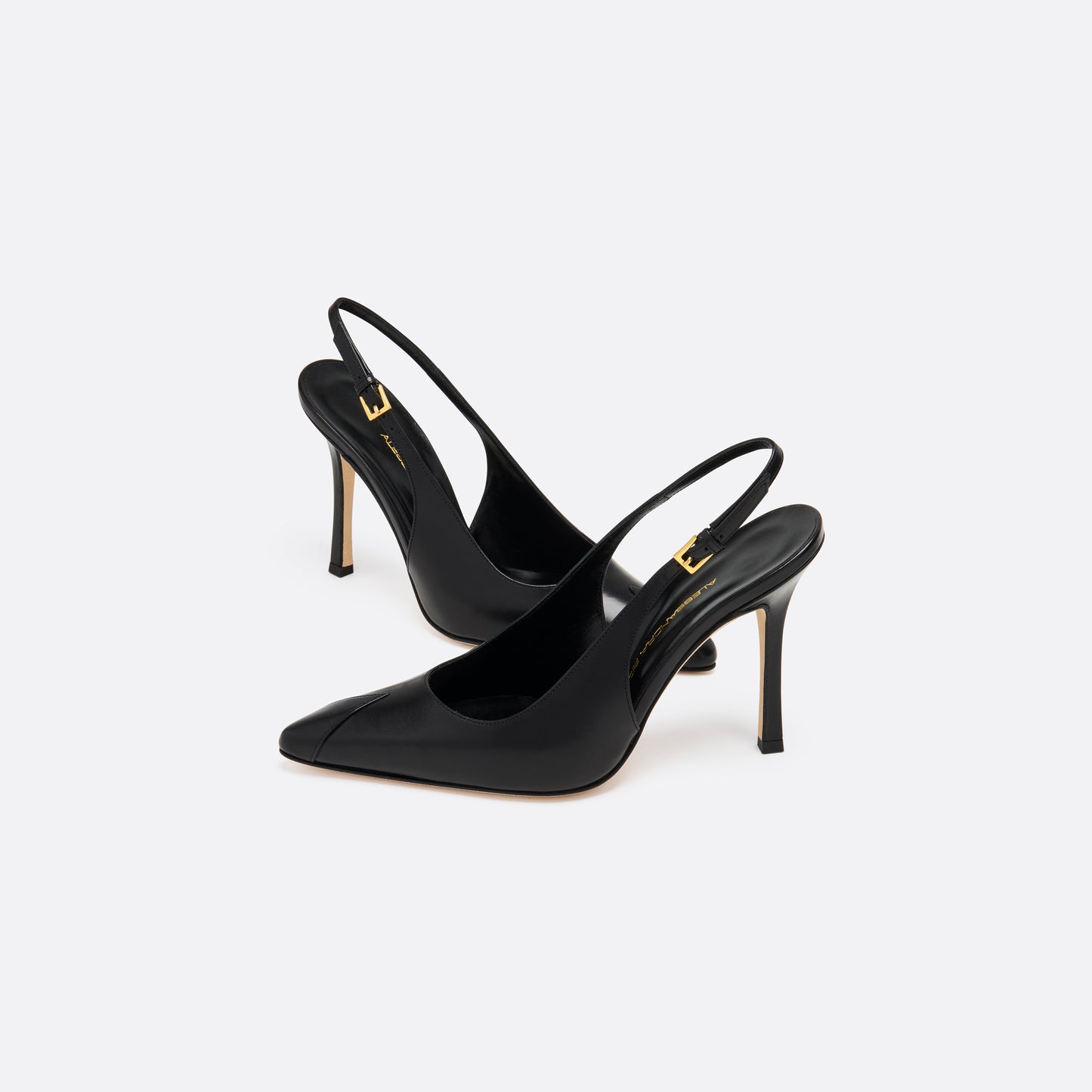 Black leather slingback pumps with a pointed toe detail and a 10.5 cm stiletto heel. Finished with an adjustable strap and a gold-tone buckle.