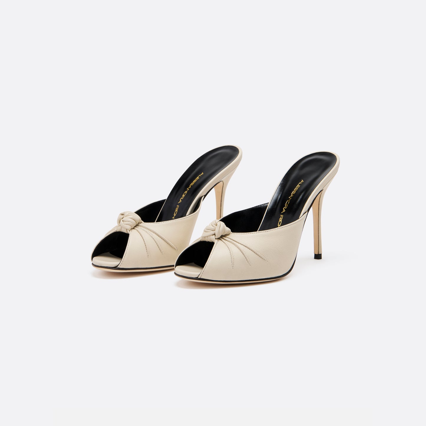 Cream leather mules with a peep toe and a 10.5 cm stiletto heel. Finished with a central knot detail.