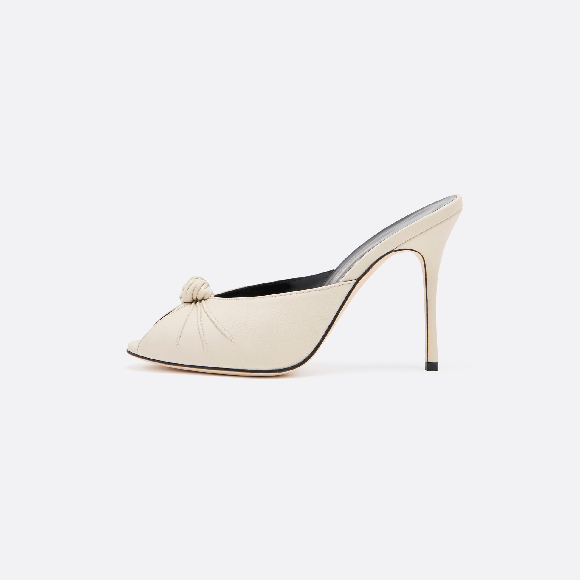 Cream leather mules with a peep toe and a 10.5 cm stiletto heel. Finished with a central knot detail.