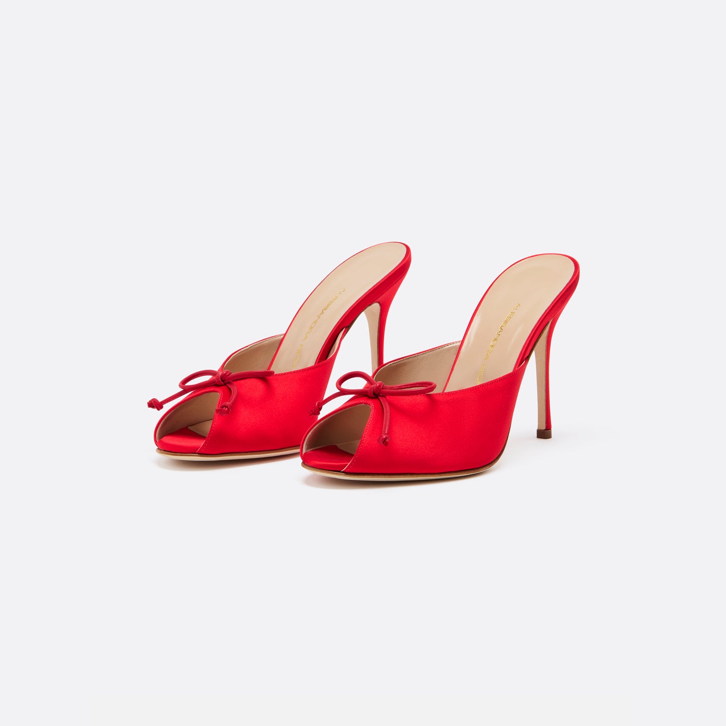 Red satin mules with a peep toe and a 10.5 cm stiletto heel. Finished with a delicate bow detail.