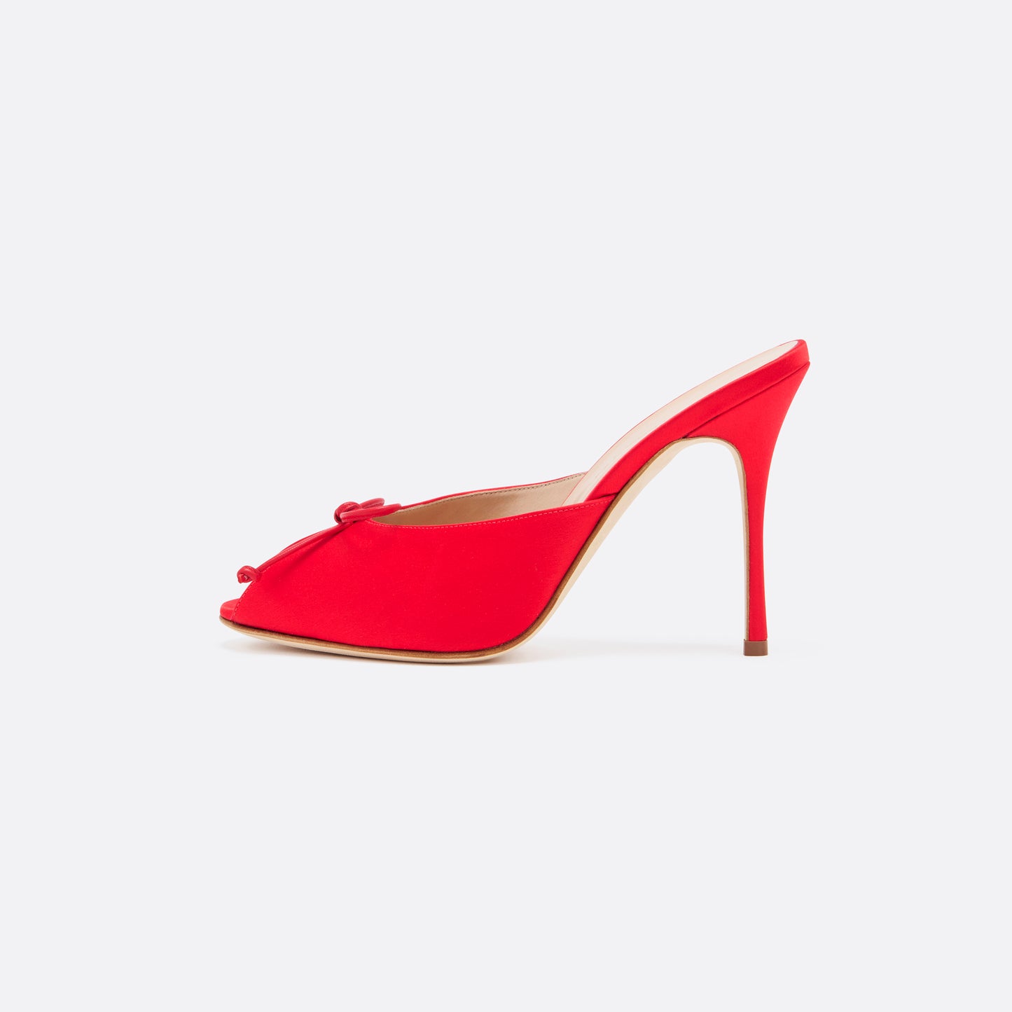 Red satin mules with a peep toe and a 10.5 cm stiletto heel. Finished with a delicate bow detail.