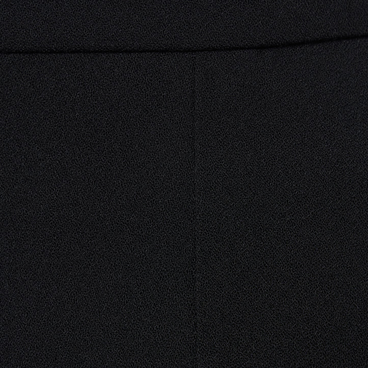 Black wool crêpe mini skirt with a high waist and a fitted silhouette.