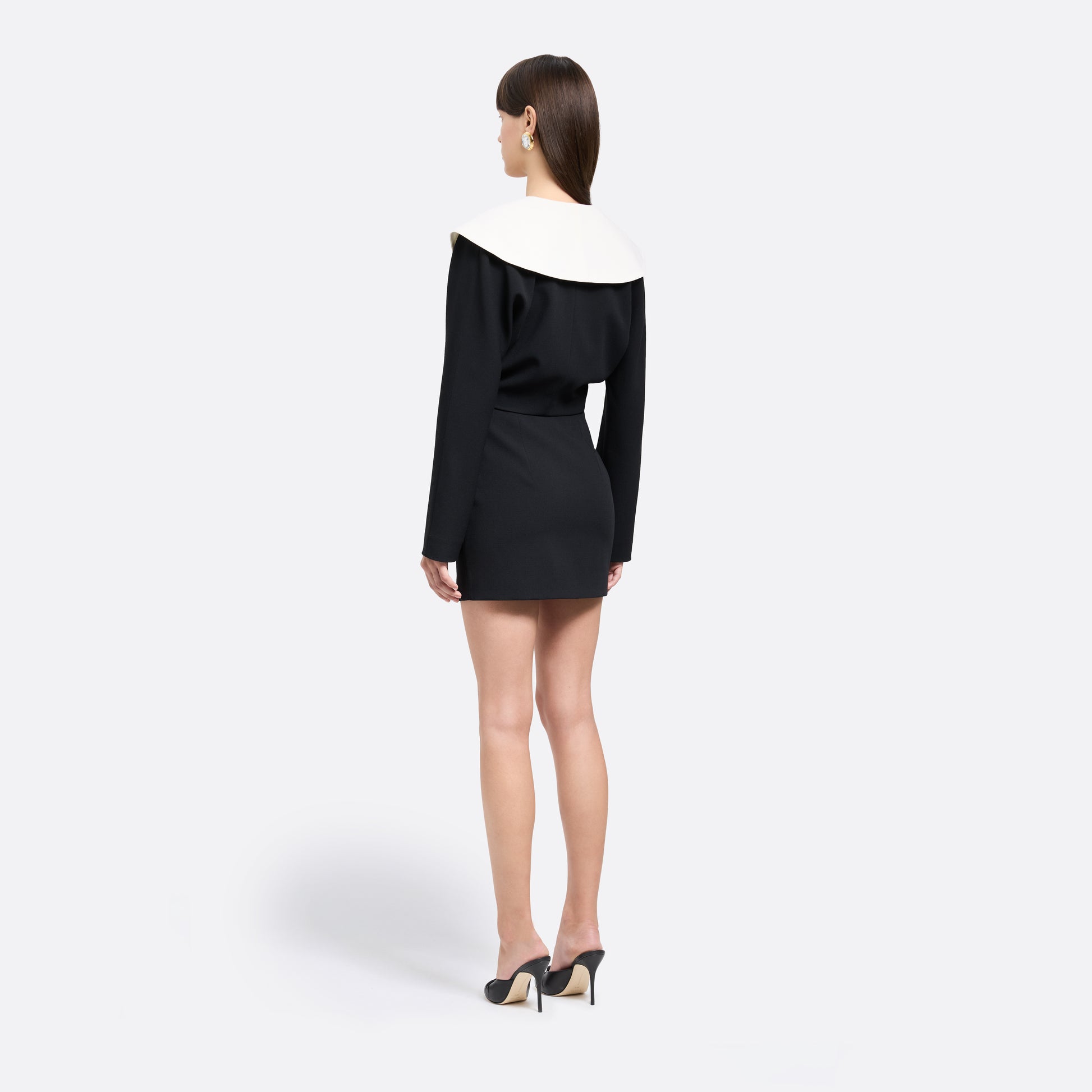 Black wool crêpe mini skirt with a high waist and a fitted silhouette.