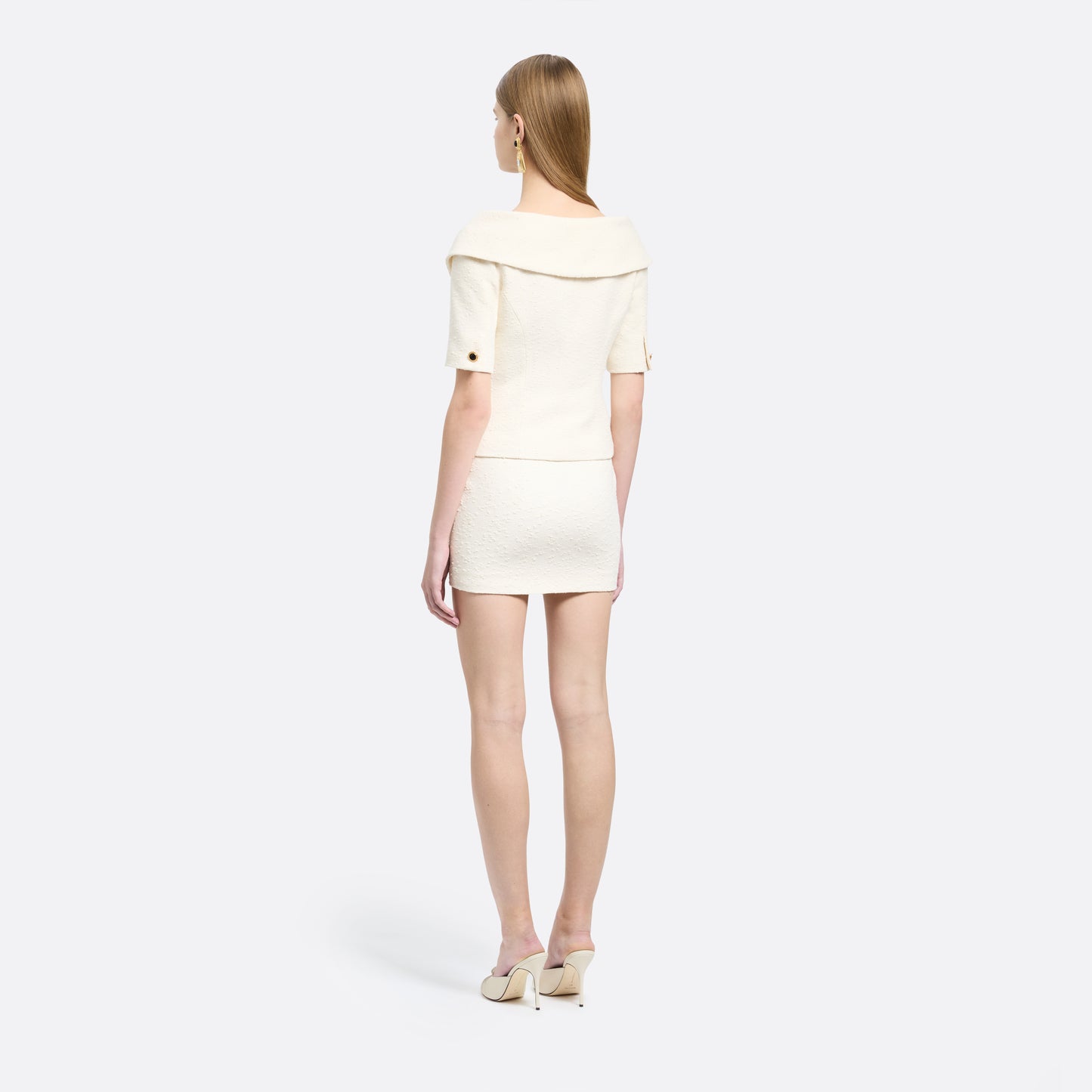 Ivory tweed bouclé mini skirt with a high waist and a fitted silhouette.