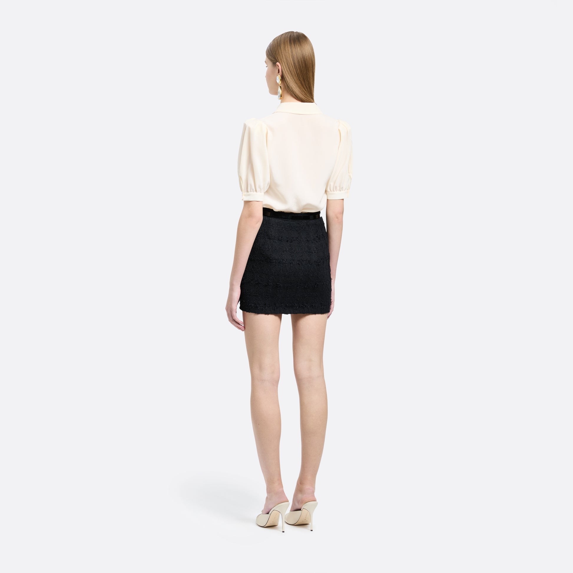 Black check tweed bouclé mini skirt with a high waist and a fitted silhouette.