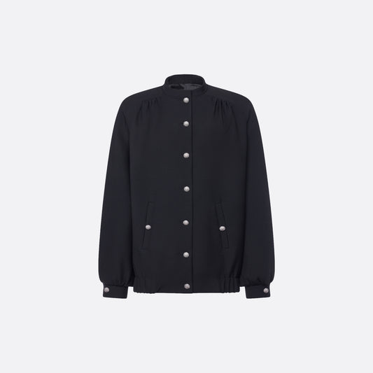 Oversized black wool blouson with a high neckline and long slevees, featuring jewel buttons.