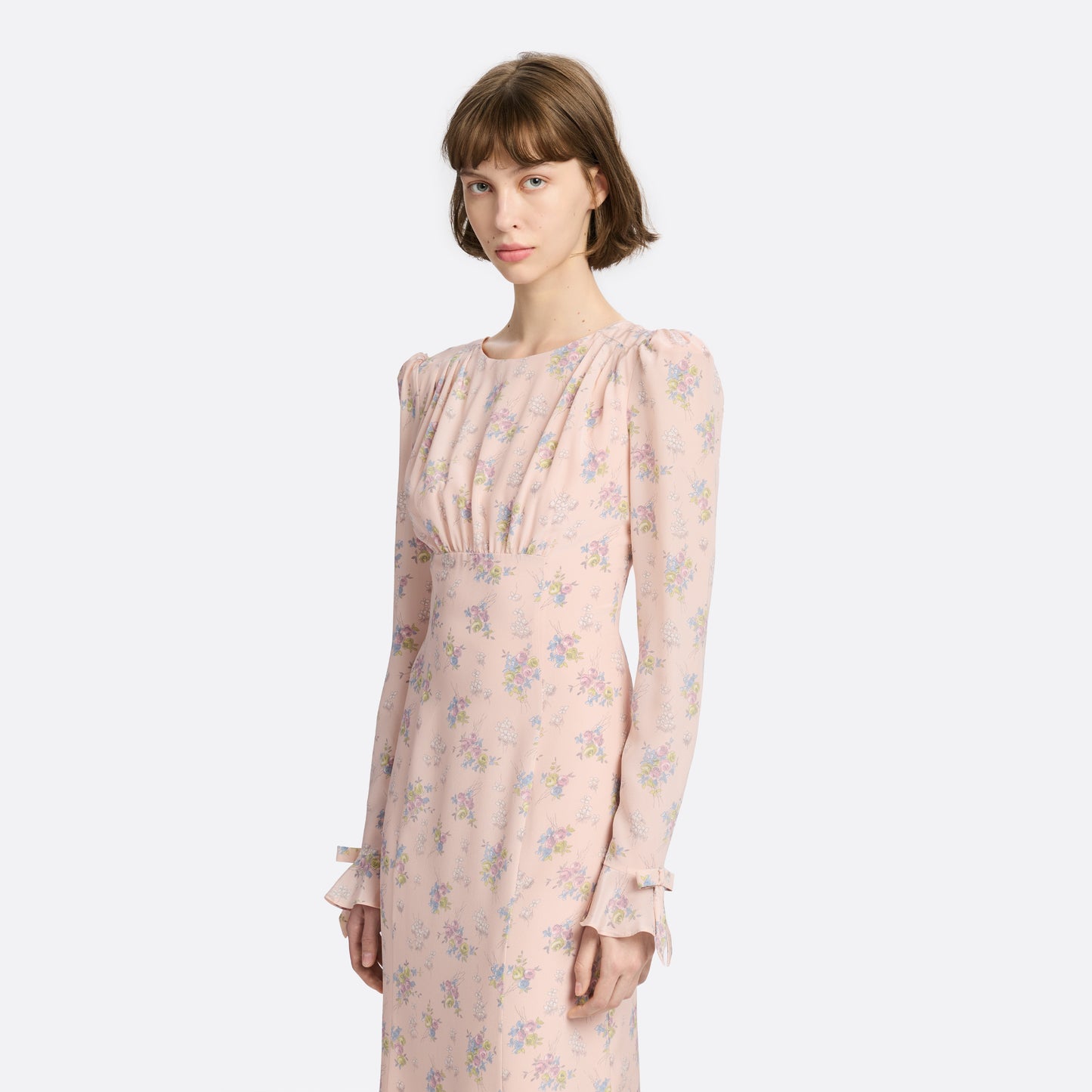 Light rose floral print silk crêpe de chine midi dress with long sleeves and open back, featuring ruffled cuffs and bows.
