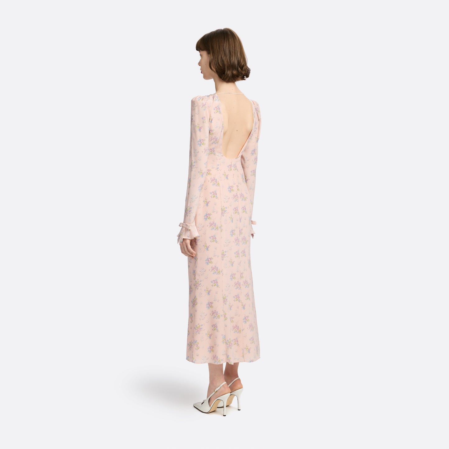 Light rose floral print silk crêpe de chine midi dress with long sleeves and open back, featuring ruffled cuffs and bows.