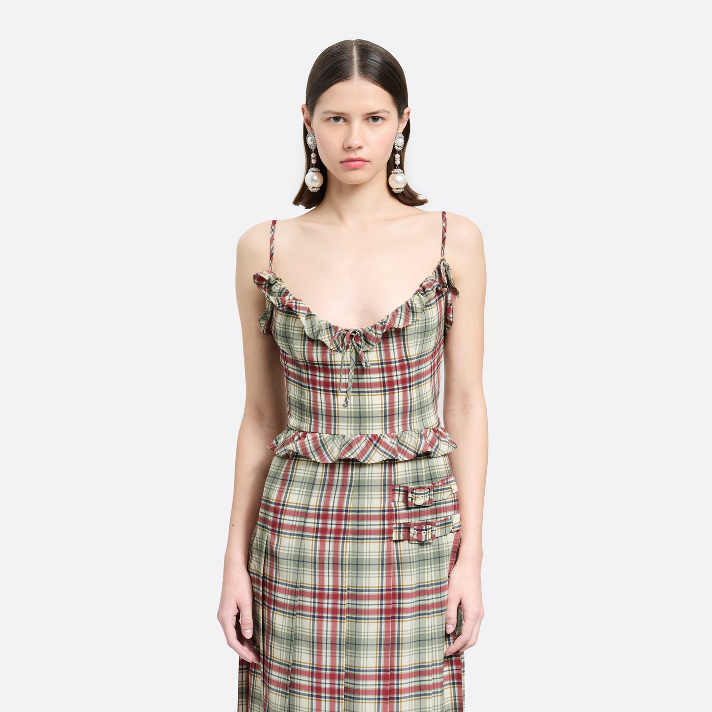 Red and green tartan-print silk crêpe de chine midi dress with spaghetti straps and a ruffled scoop neckline. The silhouette is finished with a pleated skirt with side split, a ruffled waist and buckles.