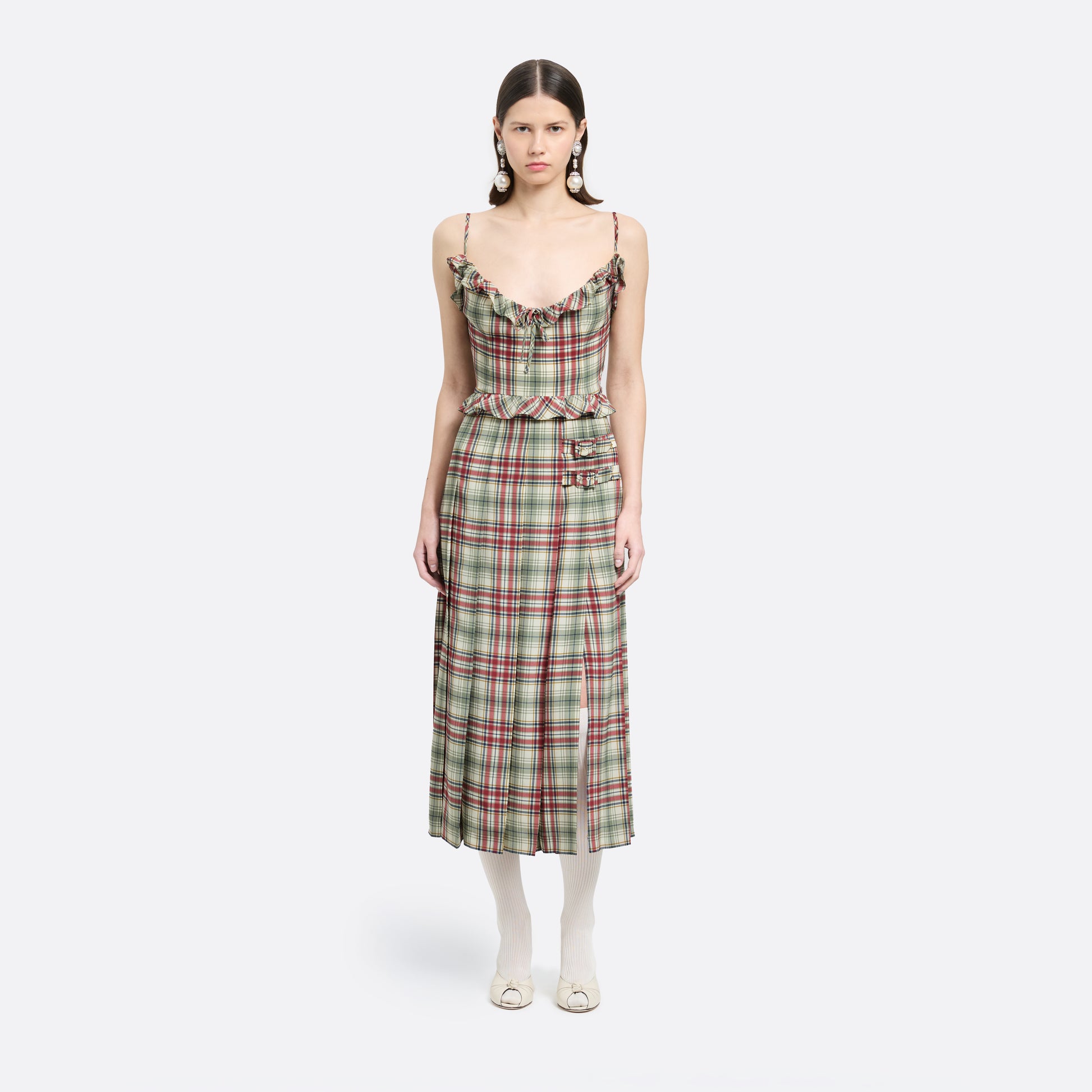 Red and green tartan-print silk crêpe de chine midi dress with spaghetti straps and a ruffled scoop neckline. The silhouette is finished with a pleated skirt with side split, a ruffled waist and buckles.
