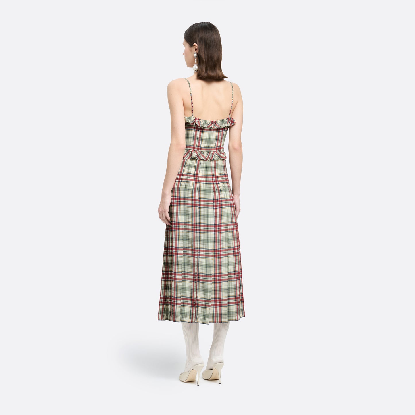 Red and green tartan-print silk crêpe de chine midi dress with spaghetti straps and a ruffled scoop neckline. The silhouette is finished with a pleated skirt with side split, a ruffled waist and buckles.