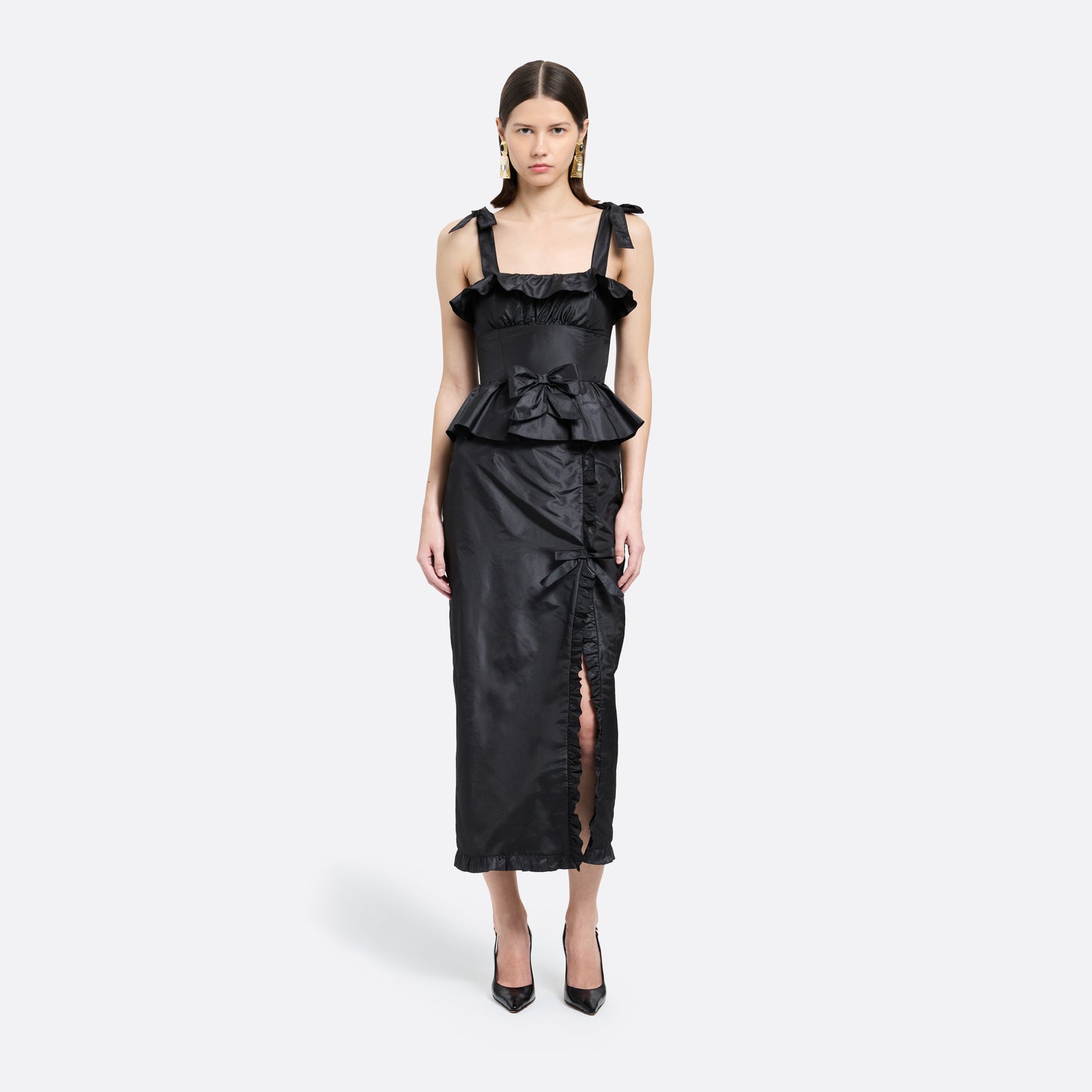Black silk taffeta midi dress with self-tie shoulder straps and a ruffled neckline. A peplum defines the silhouette, while the straight skirt is finished with a delicate ruffle trim at the split.

Look 22 – Fall Winter 2026 Lookbook.