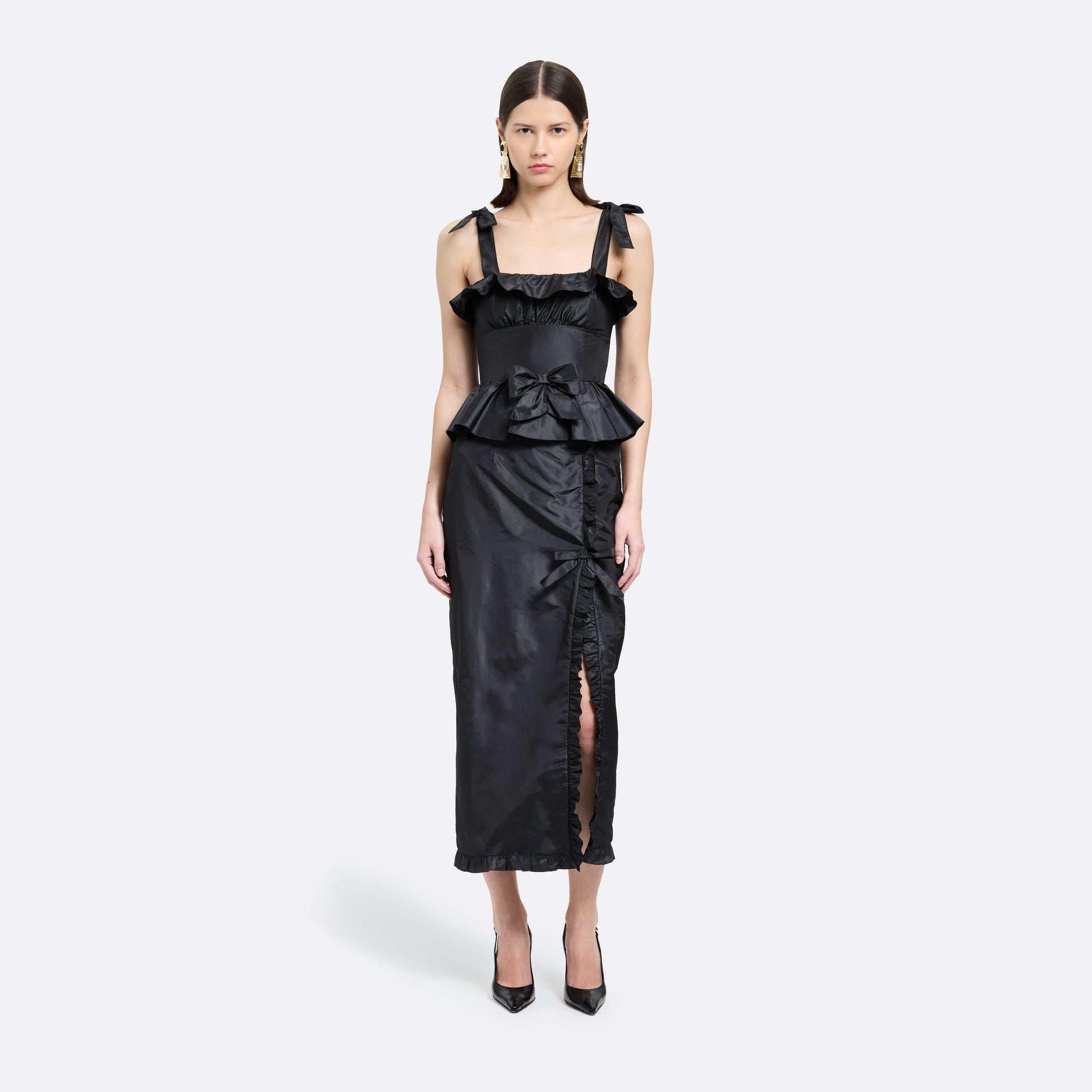Black silk taffeta midi dress with self-tie shoulder straps and a ruffled neckline. A peplum defines the silhouette, while the straight skirt is finished with a delicate ruffle trim at the split.

Look 22 – Fall Winter 2026 Lookbook.