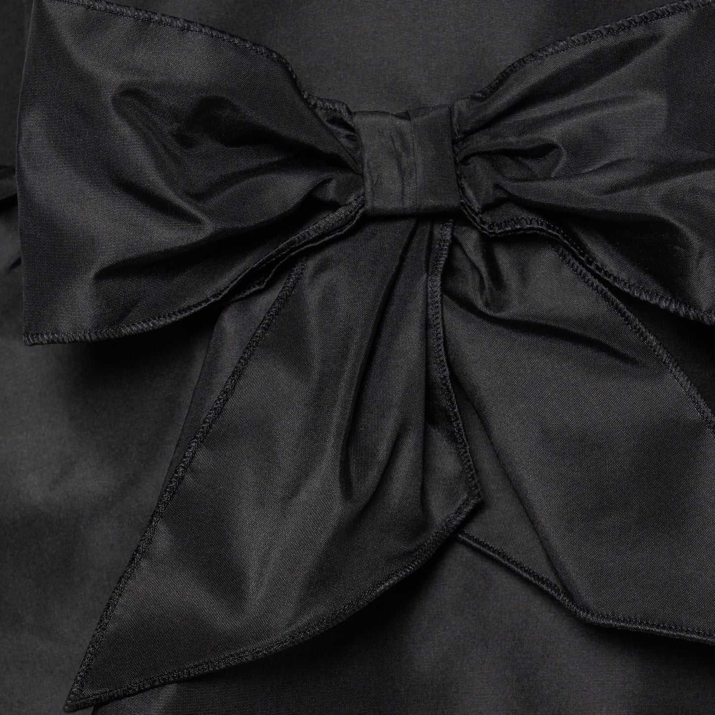Black silk taffeta midi dress with self-tie shoulder straps and a ruffled neckline. A peplum defines the silhouette, while the straight skirt is finished with a delicate ruffle trim at the split.

Look 22 – Fall Winter 2026 Lookbook.