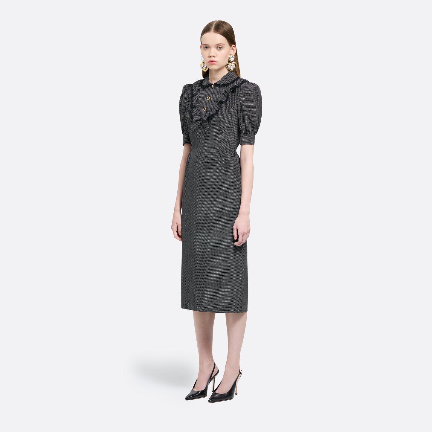 Black and white small polka-dot print silk crêpe de chine midi dress with short puffed sleeeves and black and old tone buttons. Finished with a lace trimmed collar and ruffled bib detailing.

Look 31 – Fall Winter 2026 Lookbook.