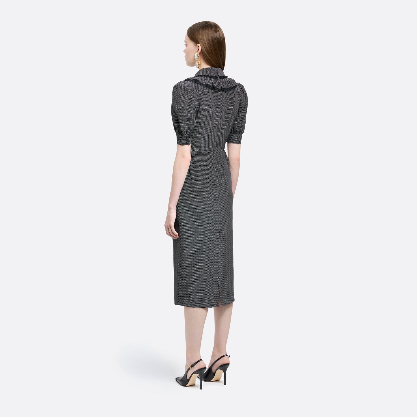 Black and white small polka-dot print silk crêpe de chine midi dress with short puffed sleeeves and black and old tone buttons. Finished with a lace trimmed collar and ruffled bib detailing.

Look 31 – Fall Winter 2026 Lookbook.