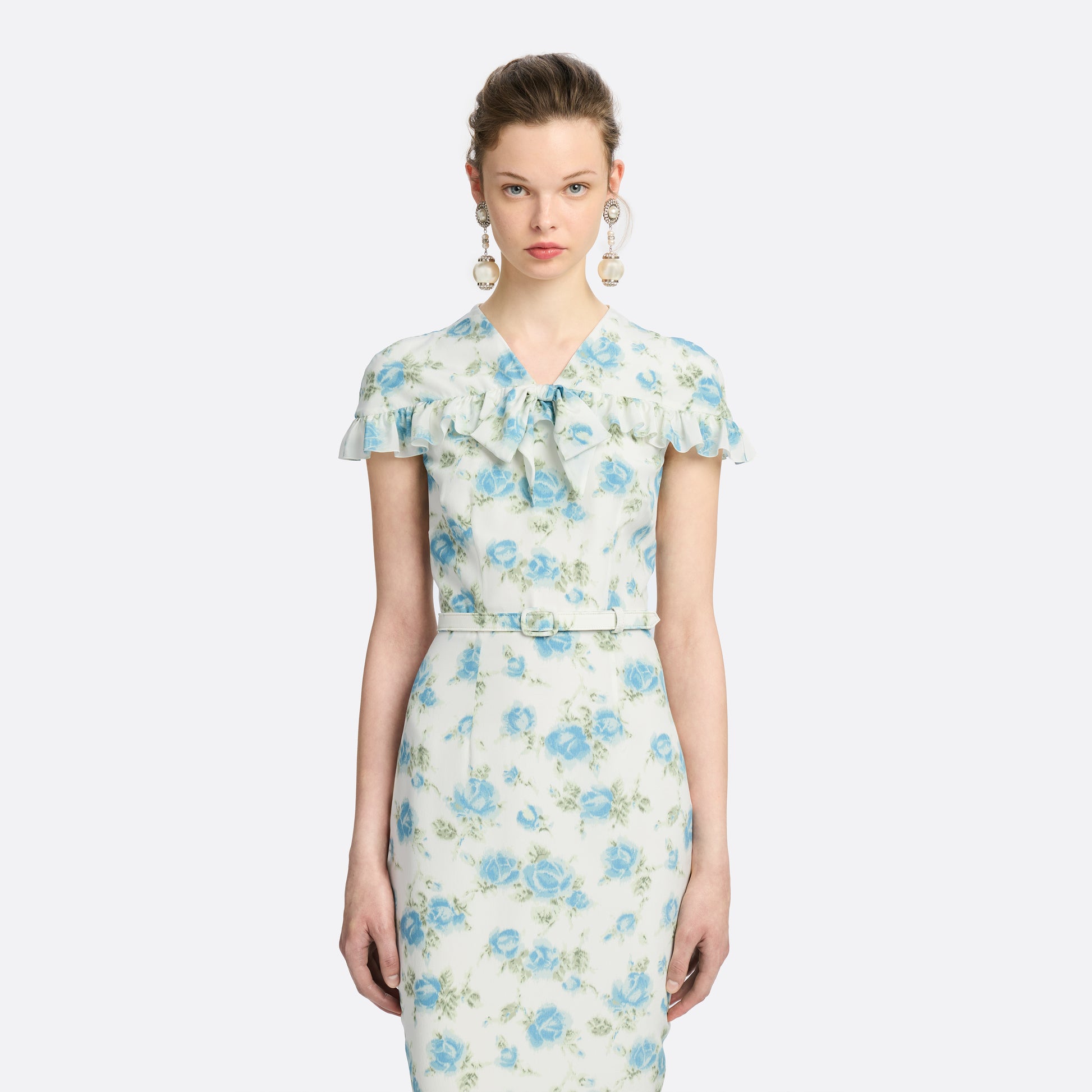 Light blue and white floral-print silk crêpe de chine midi dress with a high neckline and bow detail. With a fitted silhouette, it is finished with ruffle-trimmed short sleeves and a slim belt.

Look 14 – Fall Winter 2026 Lookbook.