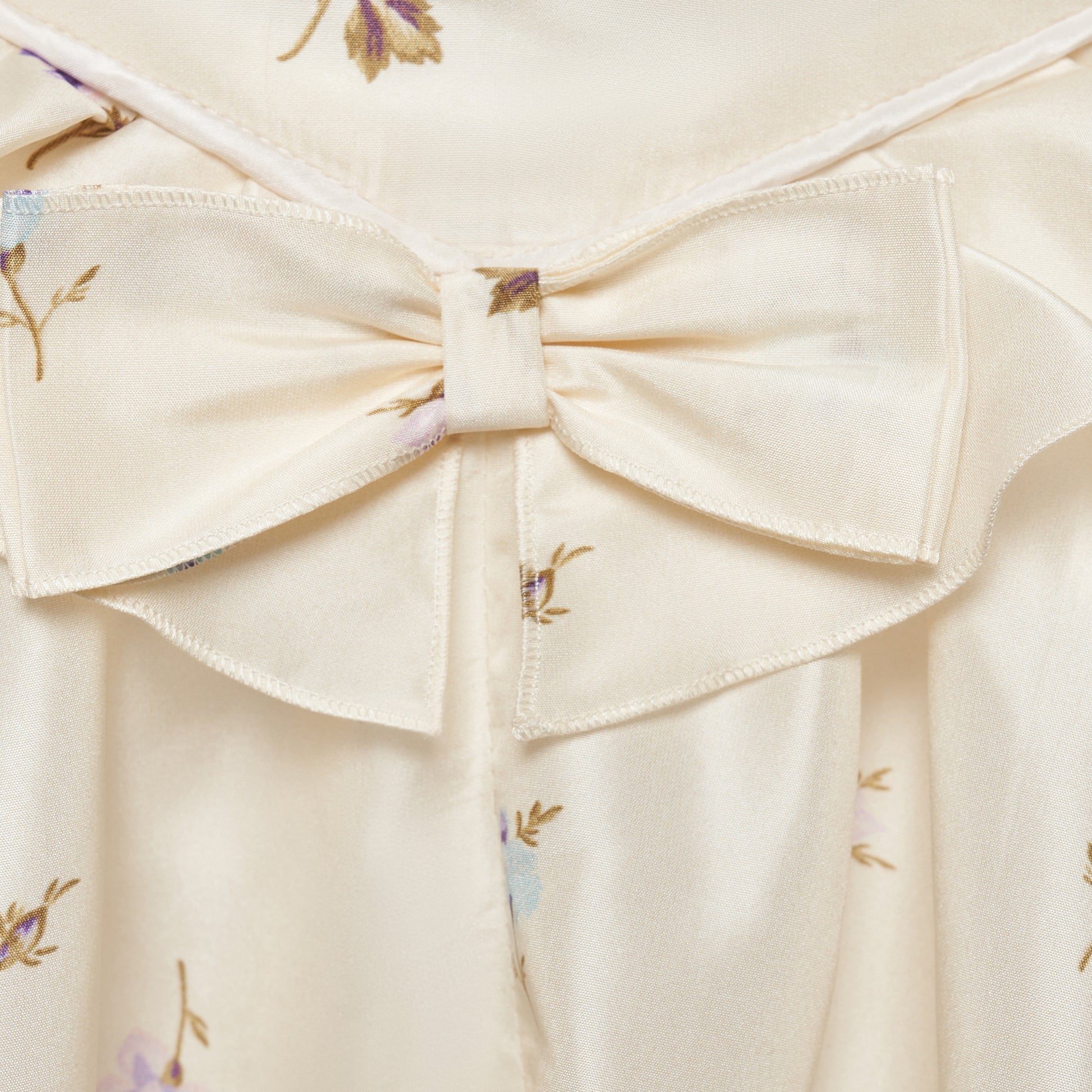 Floral-print white silk taffeta midi dress with spaghetti straps and a scoop neckline. The silhouette is finished with a flared skirt with pockets and a ruffled waist with a bow.