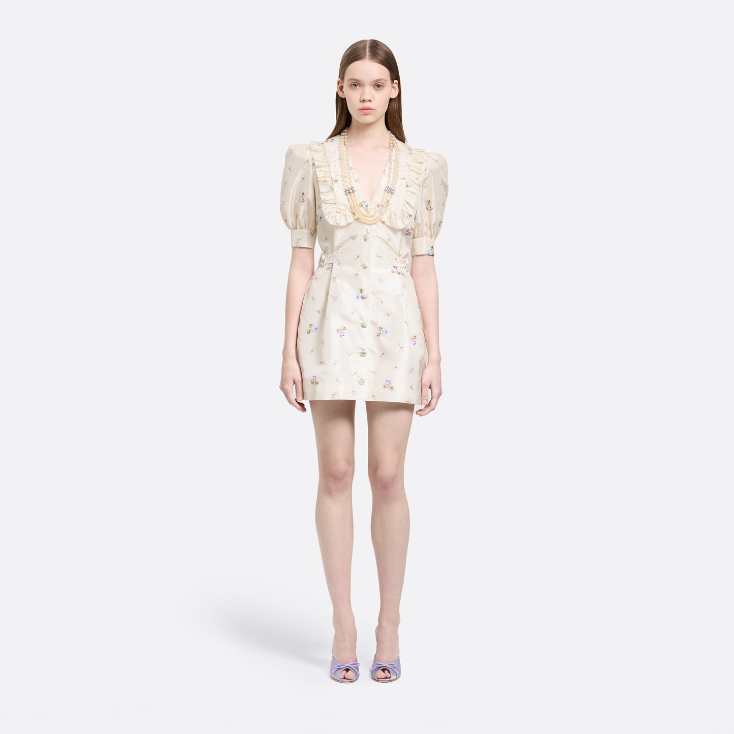 Floral-print white silk taffeta mini dress with a front button closure, ruffled collar and puff sleeves. Finished with side buckles and pockets.
