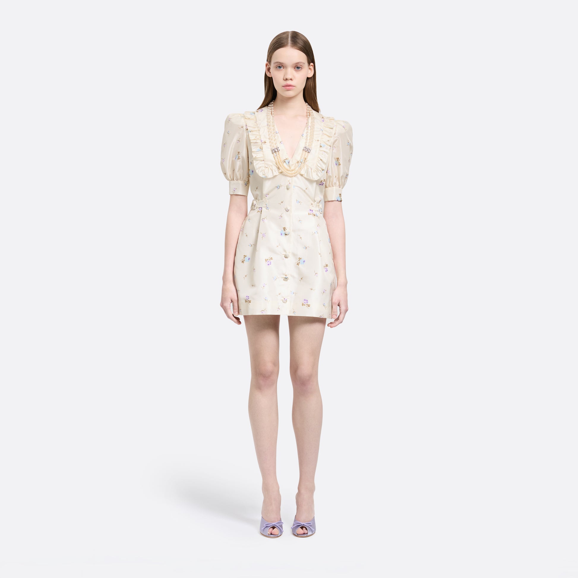 Floral-print white silk taffeta mini dress with a front button closure, ruffled collar and puff sleeves. Finished with side buckles and pockets.