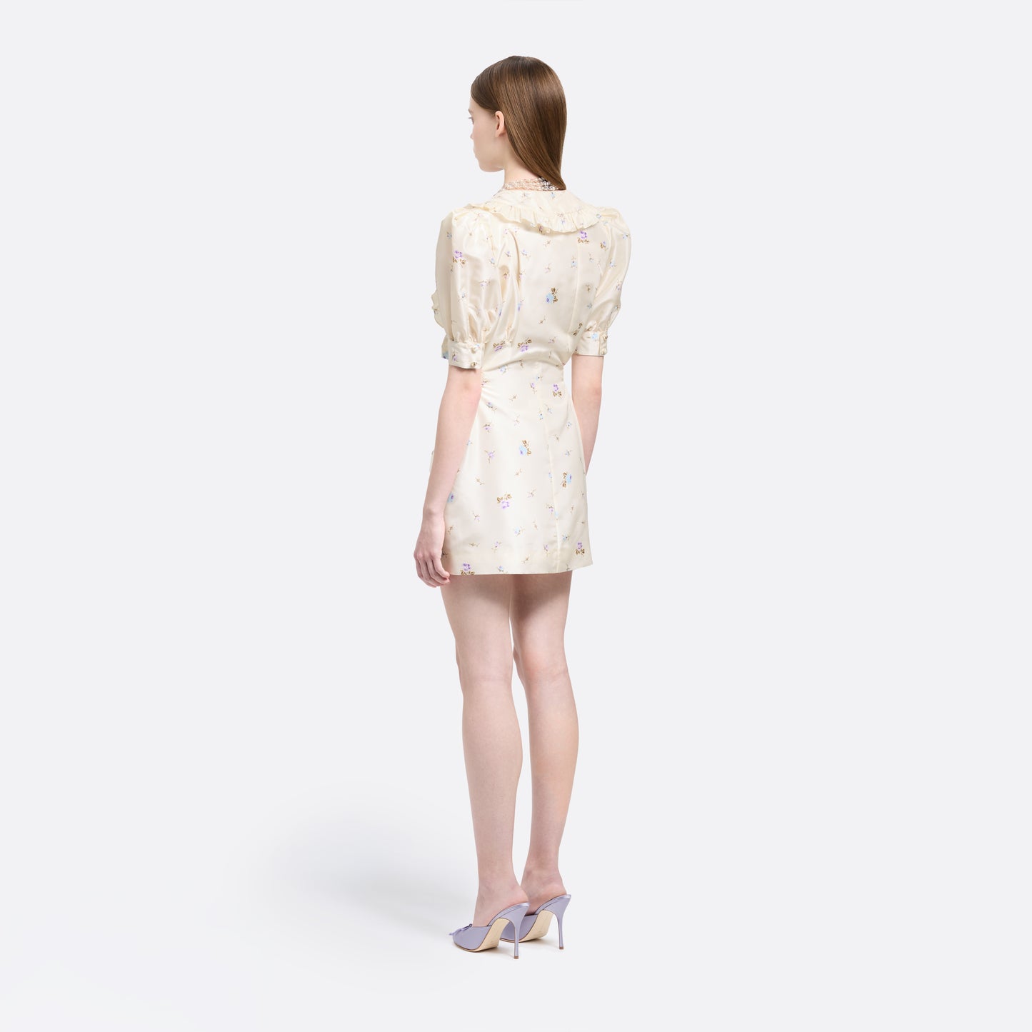 Floral-print white silk taffeta mini dress with a front button closure, ruffled collar and puff sleeves. Finished with side buckles and pockets.