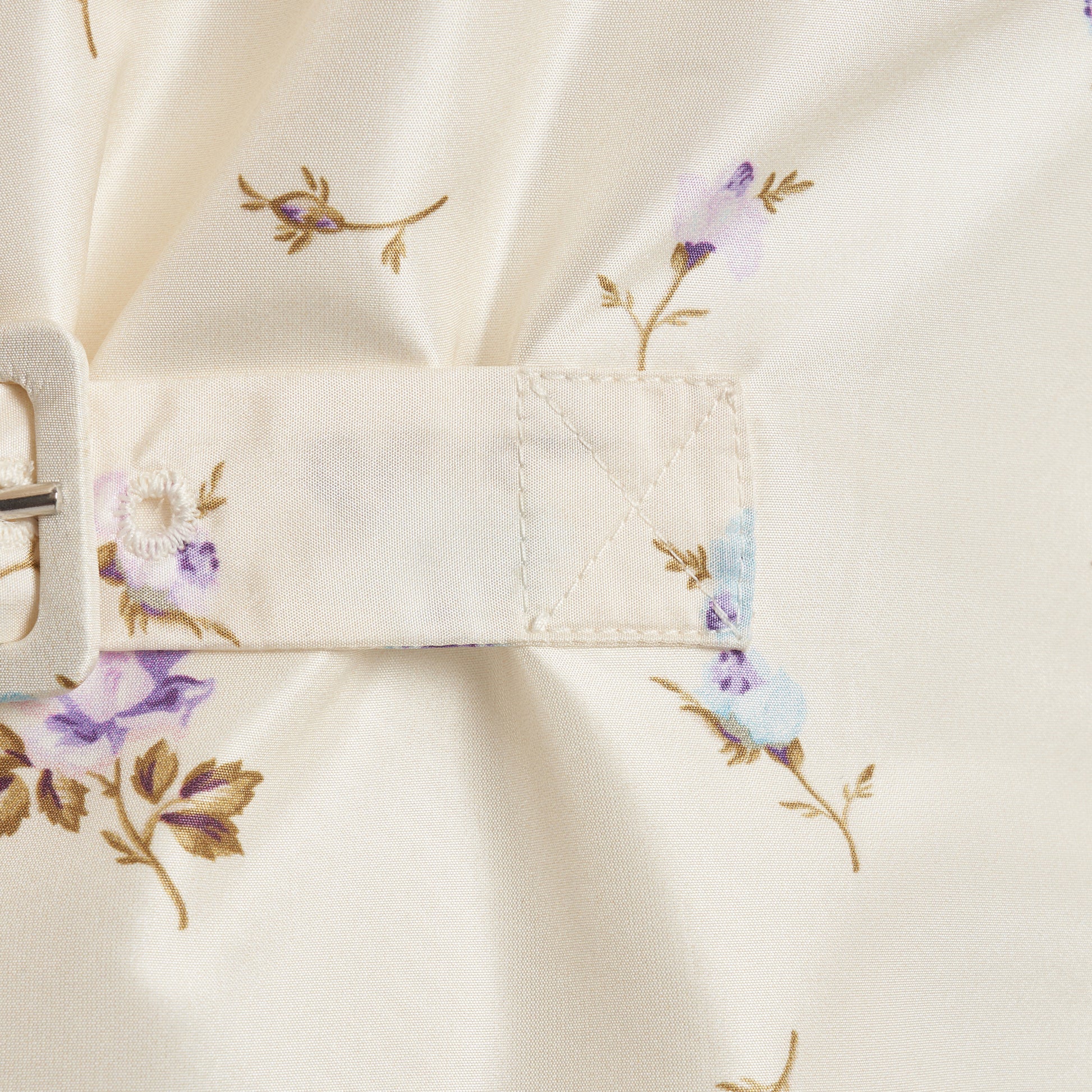 Floral-print white silk taffeta mini dress with a front button closure, ruffled collar and puff sleeves. Finished with side buckles and pockets.