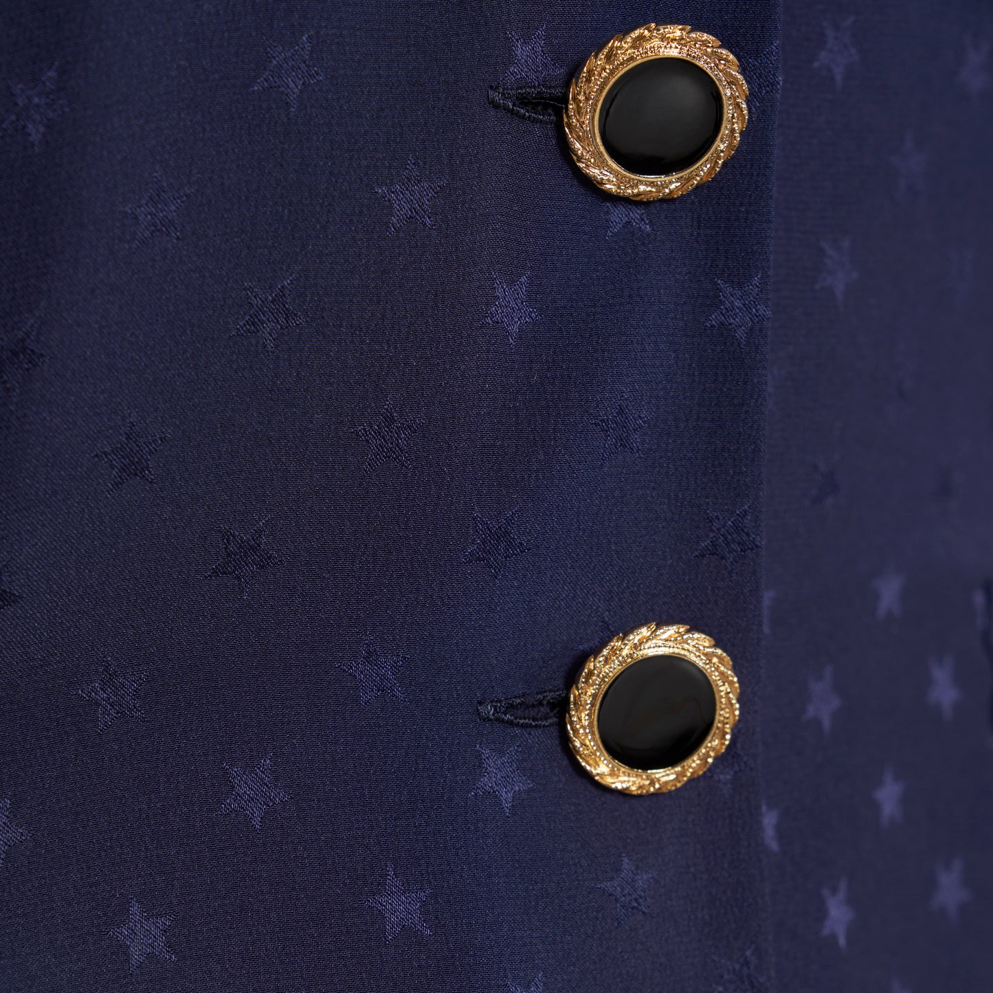 Navy blue star-jacquard silk mini dress with a front button closure, contrasting ruffled collar and puff sleeves. Finished black and gold-tone buttons, side buckles and pockets.

Look 15 – Fall Winter 2026 Lookbook.