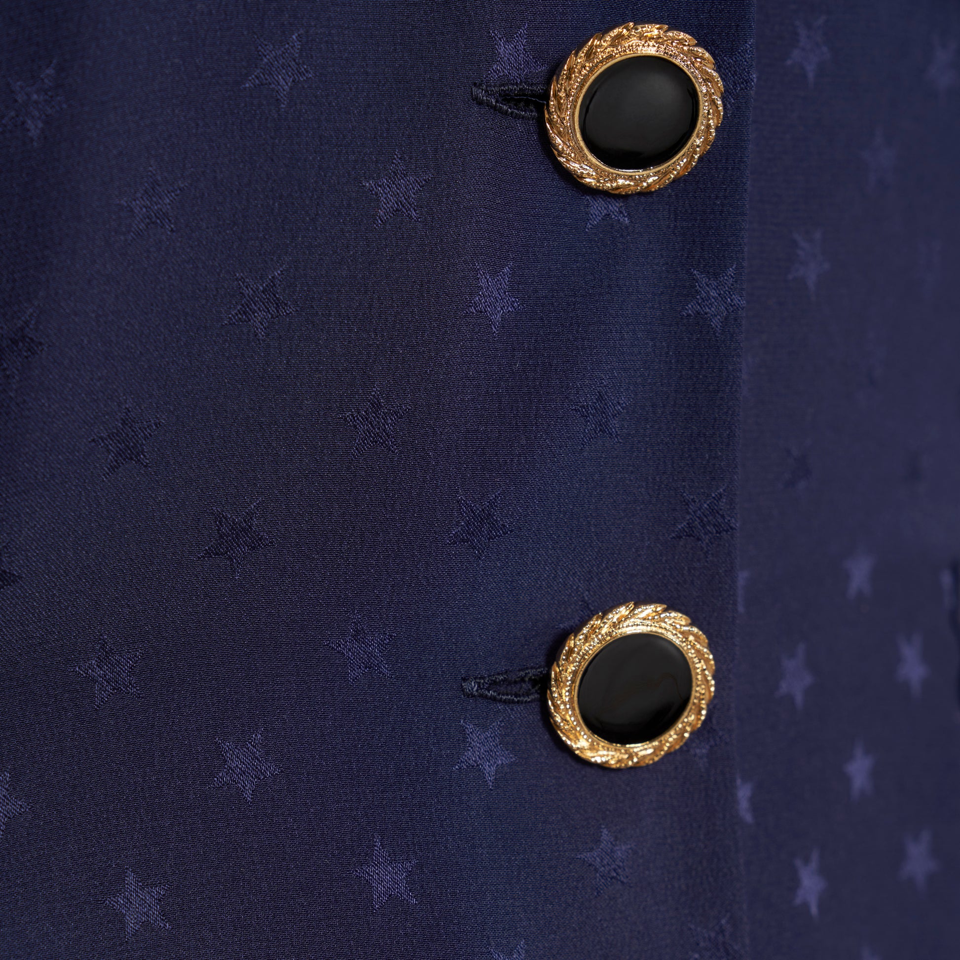 Navy blue star-jacquard silk mini dress with a front button closure, contrasting ruffled collar and puff sleeves. Finished black and gold-tone buttons, side buckles and pockets.

Look 15 – Fall Winter 2026 Lookbook.