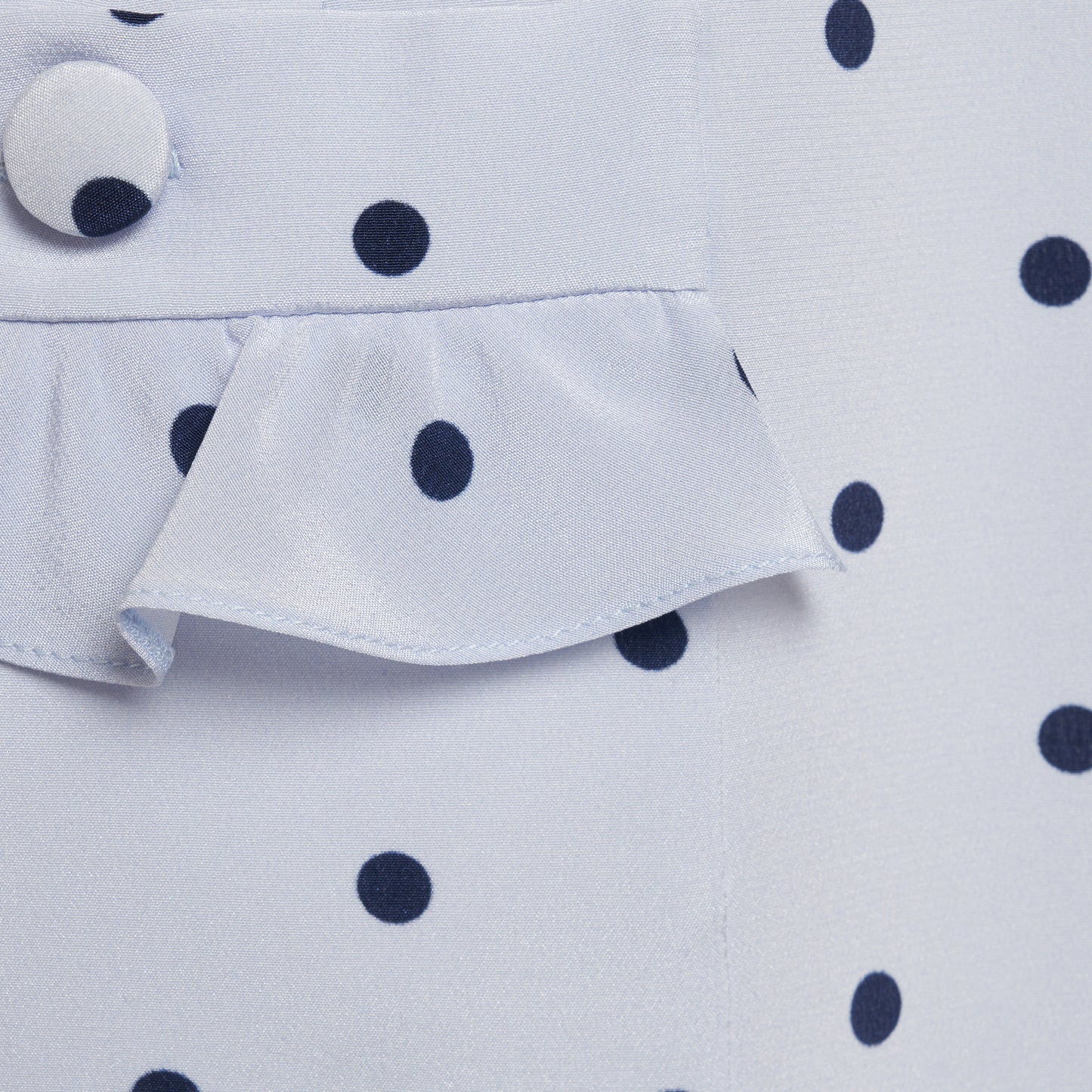 Light blue polka-dot silk crêpe de chine mini dress with bow-detailed shoulder straps and a ruffled neckline. The fitted silhouette is finished with patch pockets and a ruffled hem.