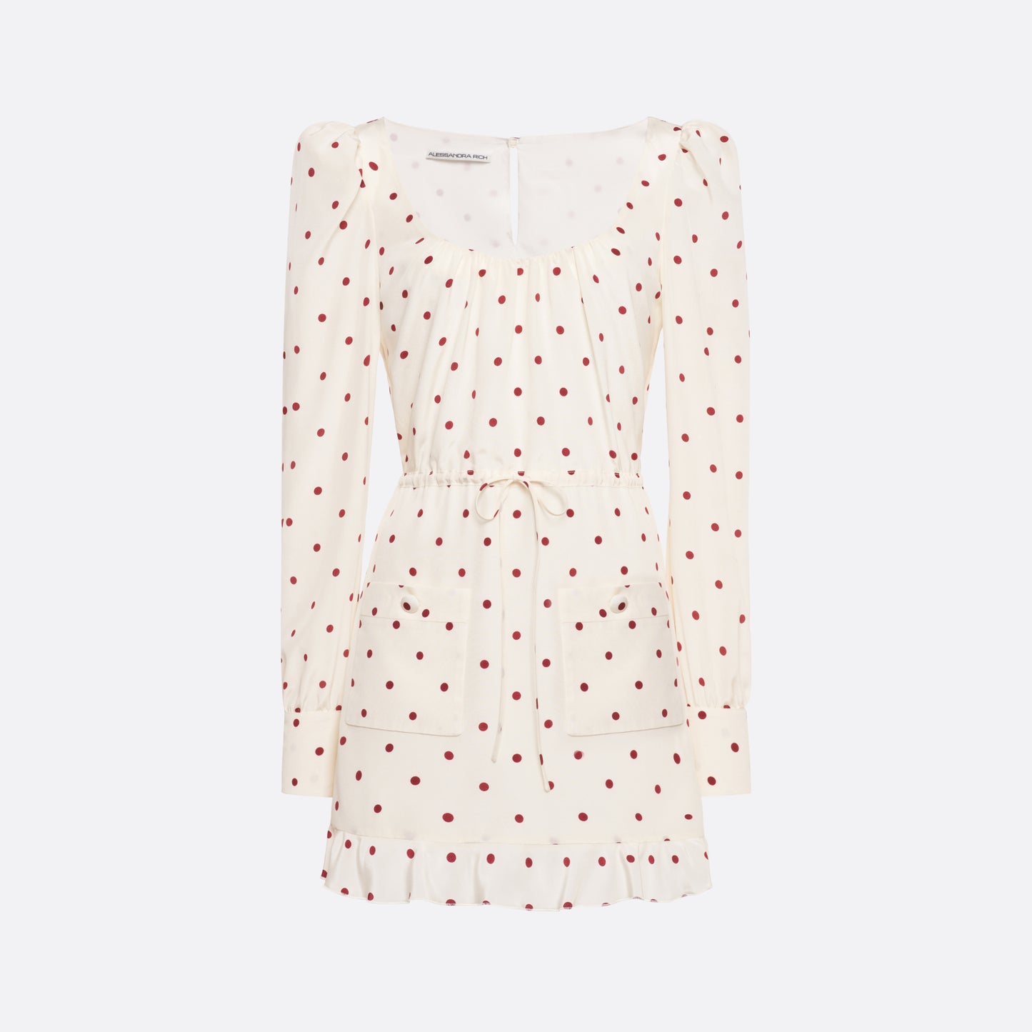 Cream and bordeaux polka-dot silk crêpe de chine mini dress with a scooped neckline and long sleeves. Defined by a drawstring waist, the silhouette is finished with patch pockets and a volant hem.