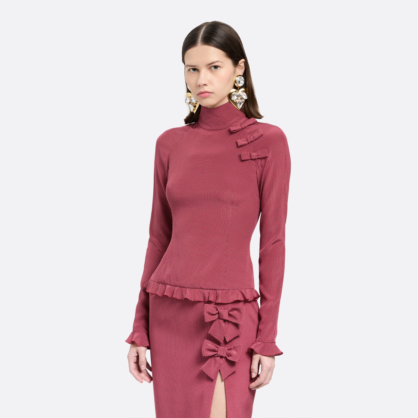 Bordeaux and white small polka-dot print silk crêpe de chine midi dress cut to a fitted silhouette with a high neckline and long sleeves. Finished with ruffled trims and bows.

Look 1 – Fall Winter 2026 Lookbook.