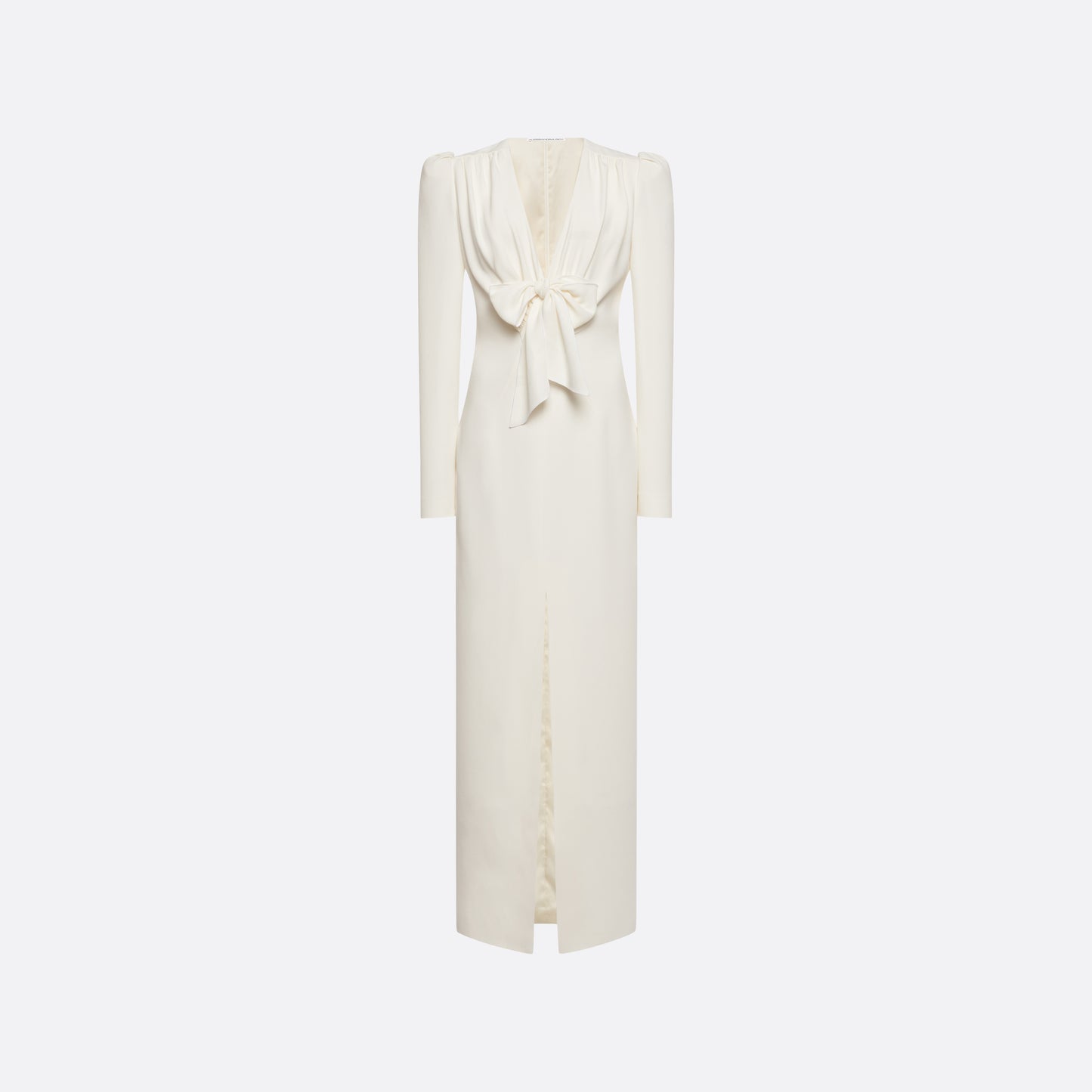 White cady evening dress cut to a fitted silhouette with a V-neckline and long sleeves. Finished with a bow detail and front split.