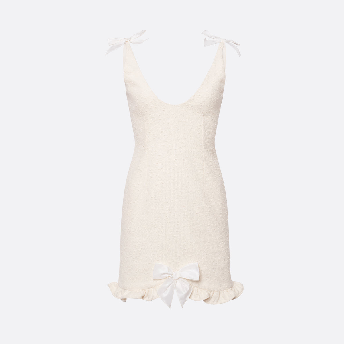 White tweed bouclé mini dress with a fitted silhouette and a soft ruffle at the hem. The shoulder straps are finished with silk bows.