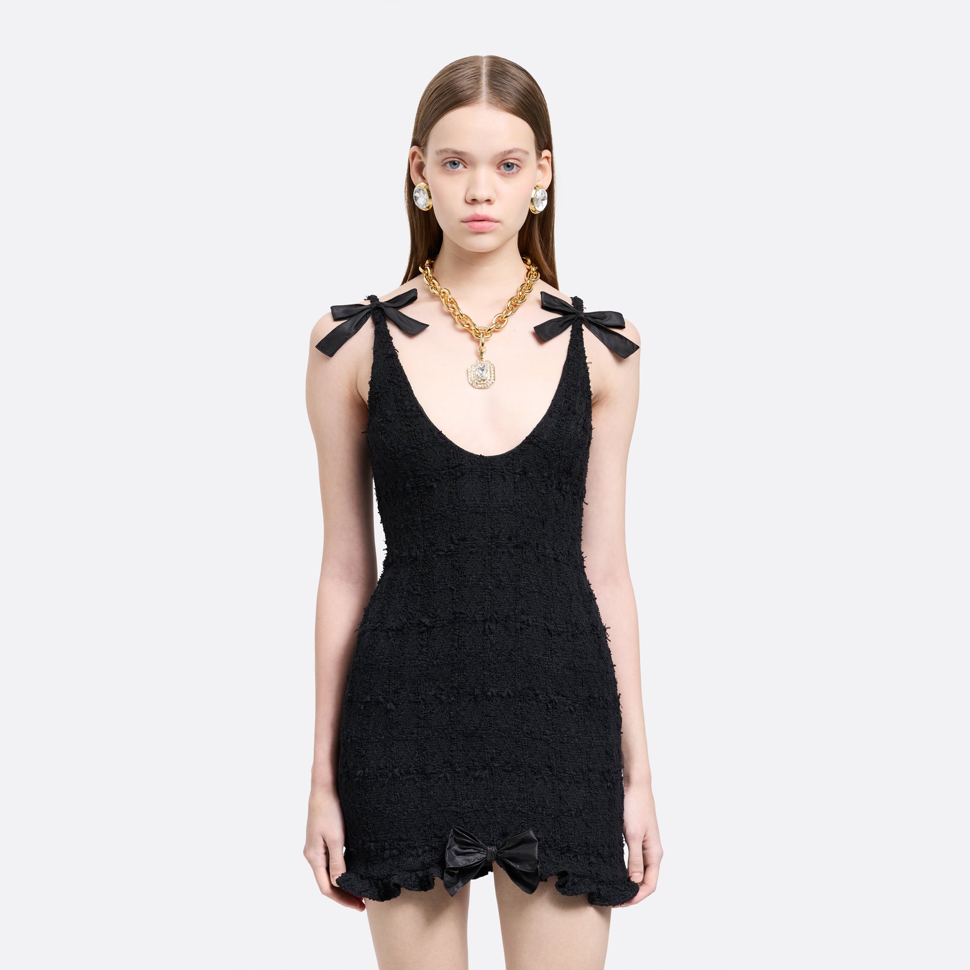 Black check tweed bouclé mini dress with a fitted silhouette and a soft ruffle at the hem. The shoulder straps are finished with bows.

Look 16 – Fall Winter 2026 Lookbook.