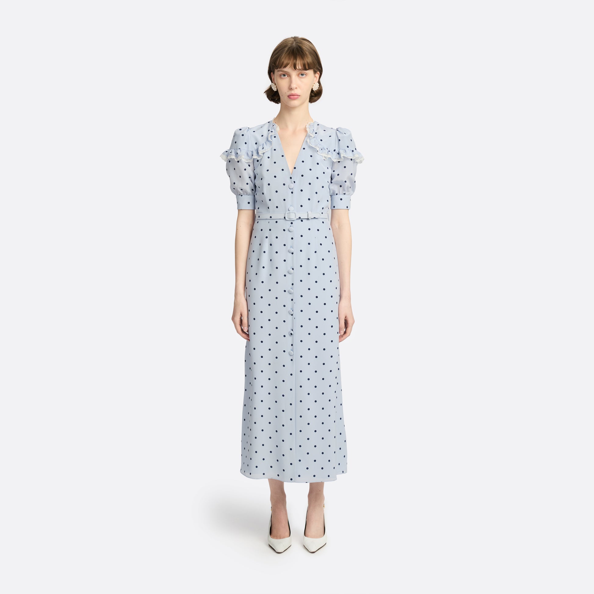Light blue polka-dot silk midi dress with a V-neckline, front button closure and short puff sleeves detailed with lace-trimmed ruffles. Finished with a slim belt.