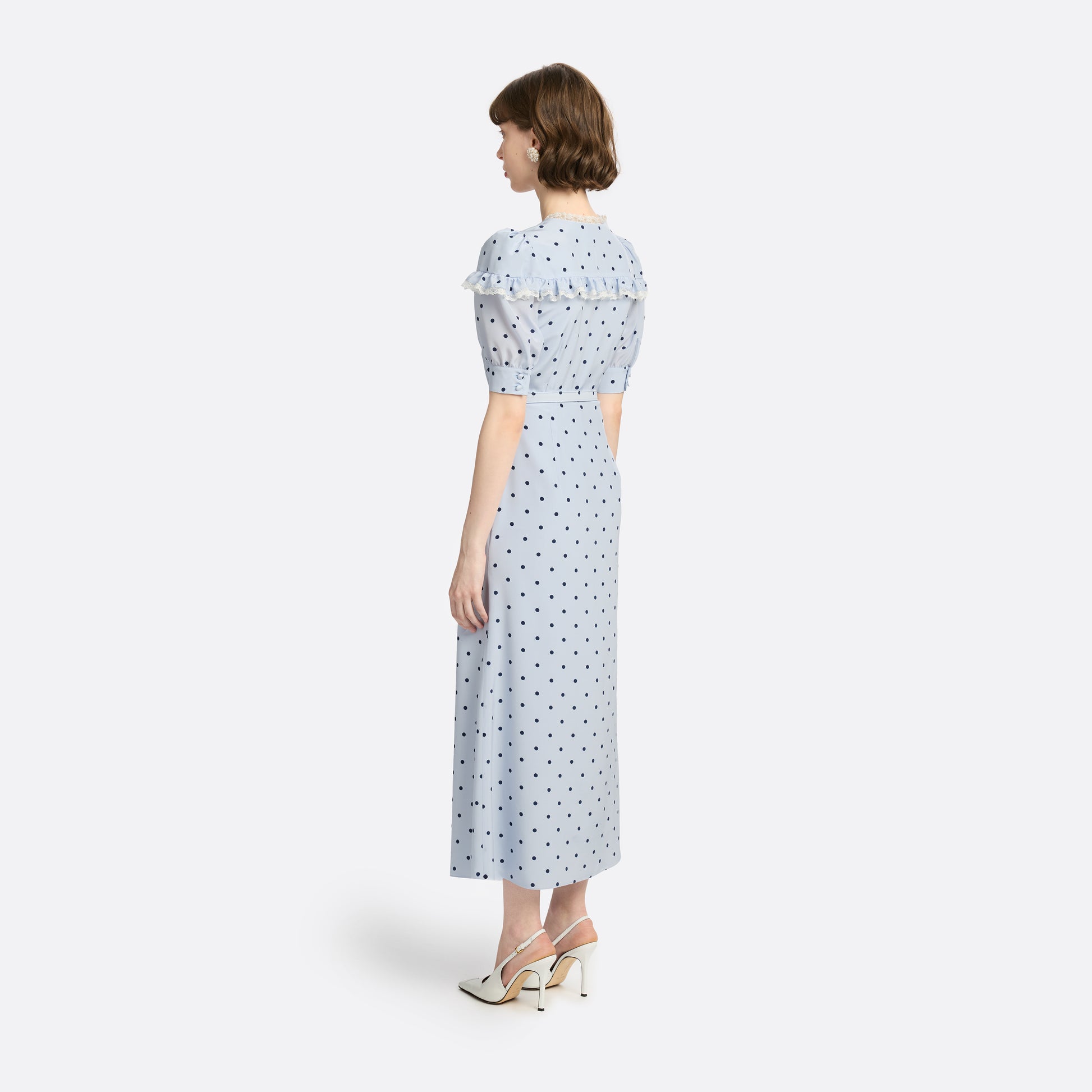 Light blue polka-dot silk midi dress with a V-neckline, front button closure and short puff sleeves detailed with lace-trimmed ruffles. Finished with a slim belt.