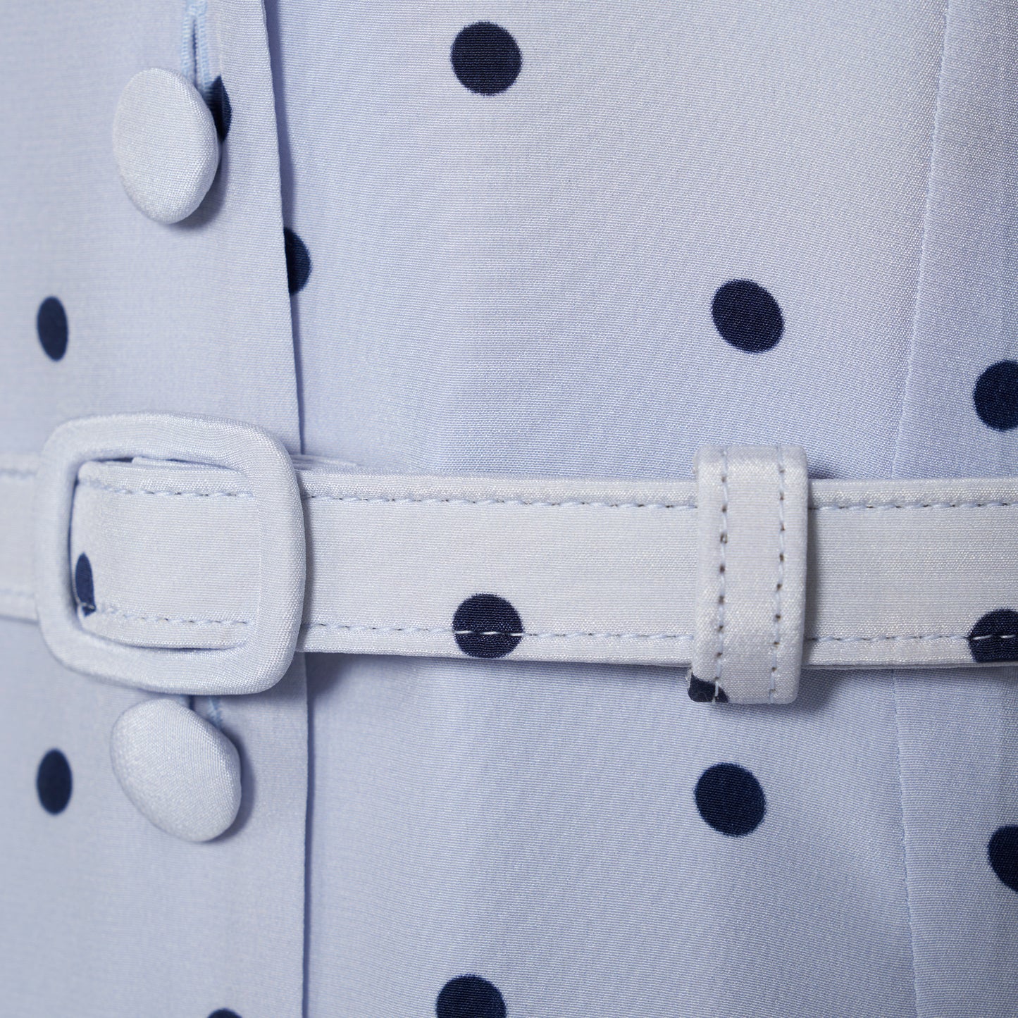 Light blue polka-dot silk midi dress with a V-neckline, front button closure and short puff sleeves detailed with lace-trimmed ruffles. Finished with a slim belt.