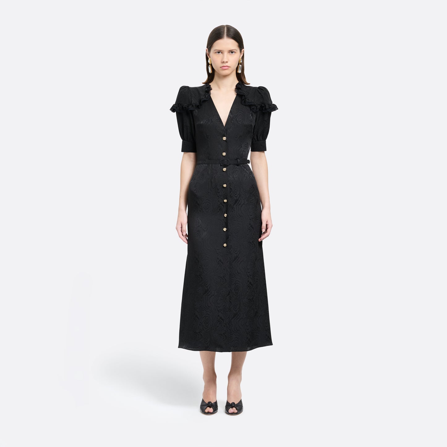 Black moiré silk jacquard midi dress with a V-neckline, front button closure and short puff sleeves detailed with lace-trimmed ruffles. Finished with jewel buttons and a slim belt.